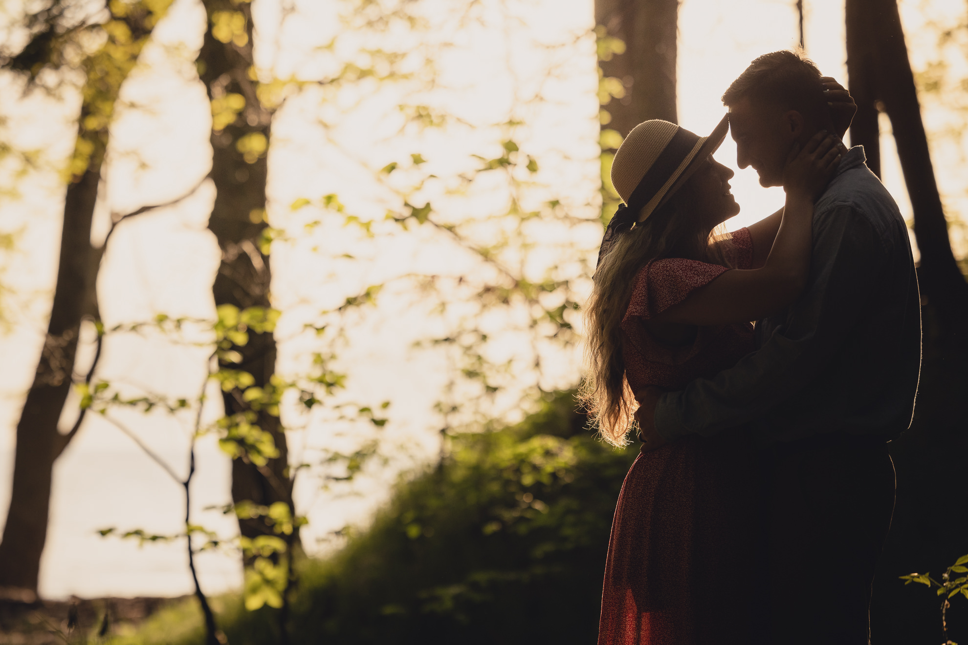 couple looks at each other during wedding engagement proposal photography in woods by Lake Ontario Beach in Niagara County