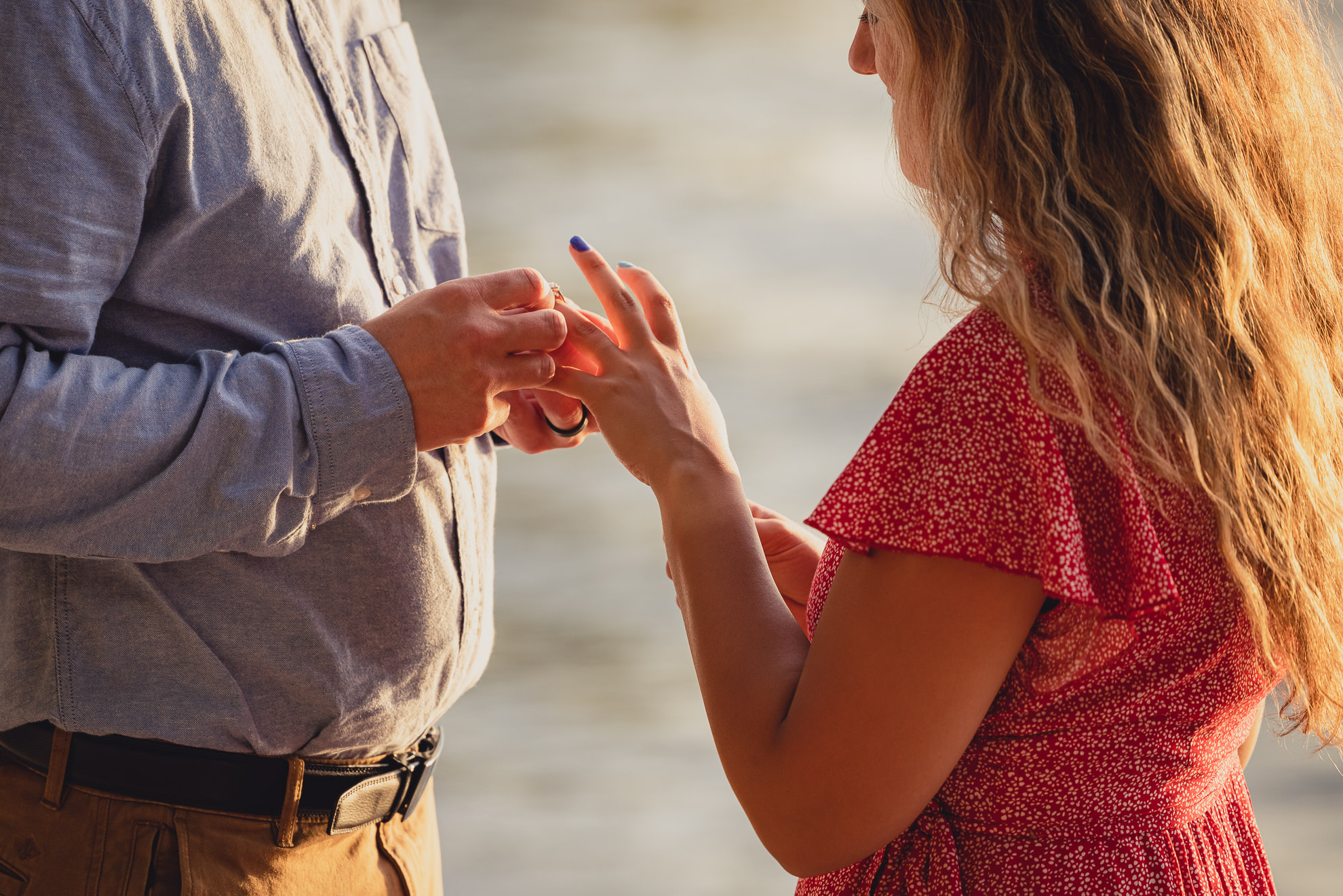 man proposes to woman on Lake Ontario beach at sunset during wedding engagement proposal photography in Niagara County