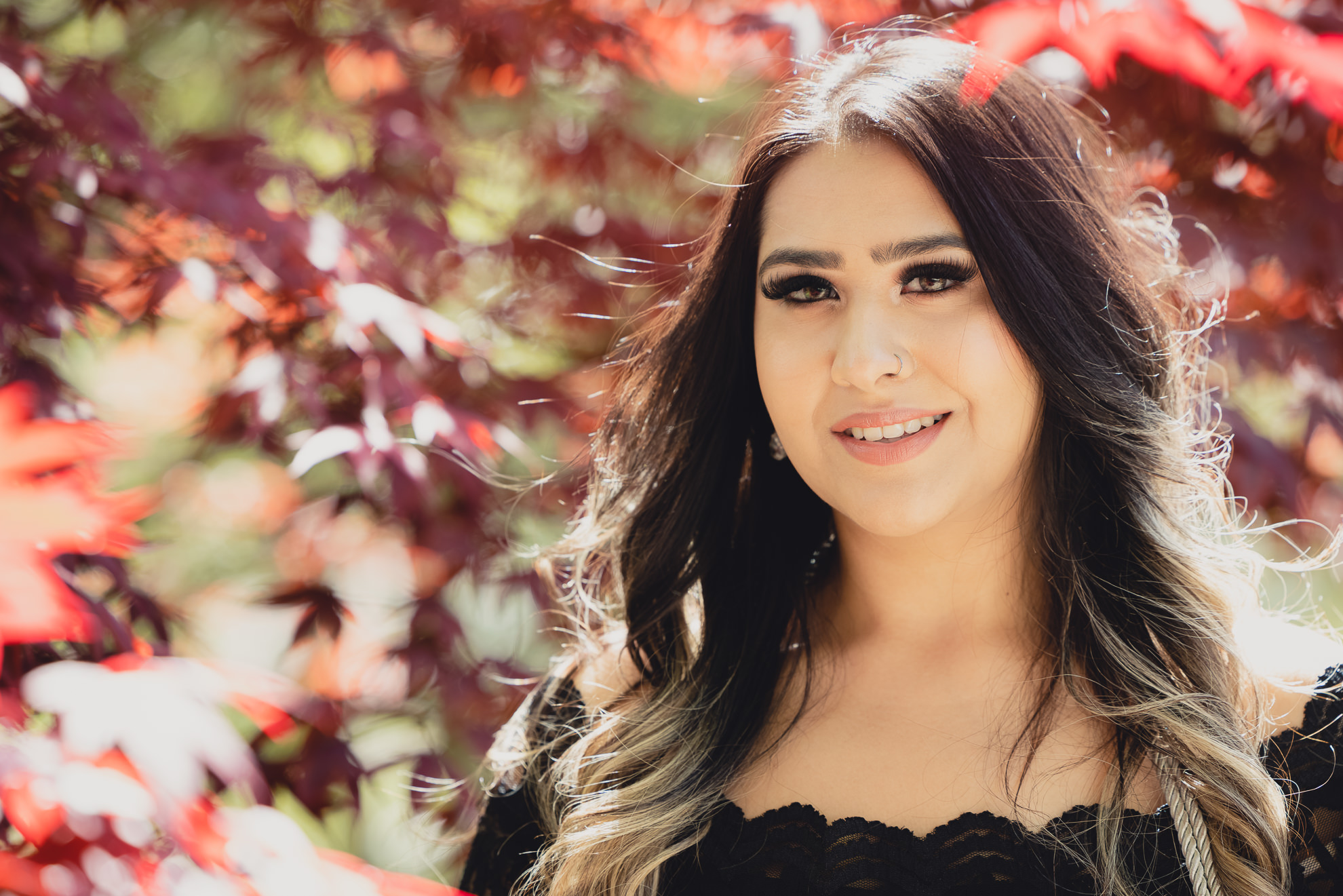 graduate smiles for photographer during senior graduation portrait photography at the Japanese Gardens in Buffalo, NY