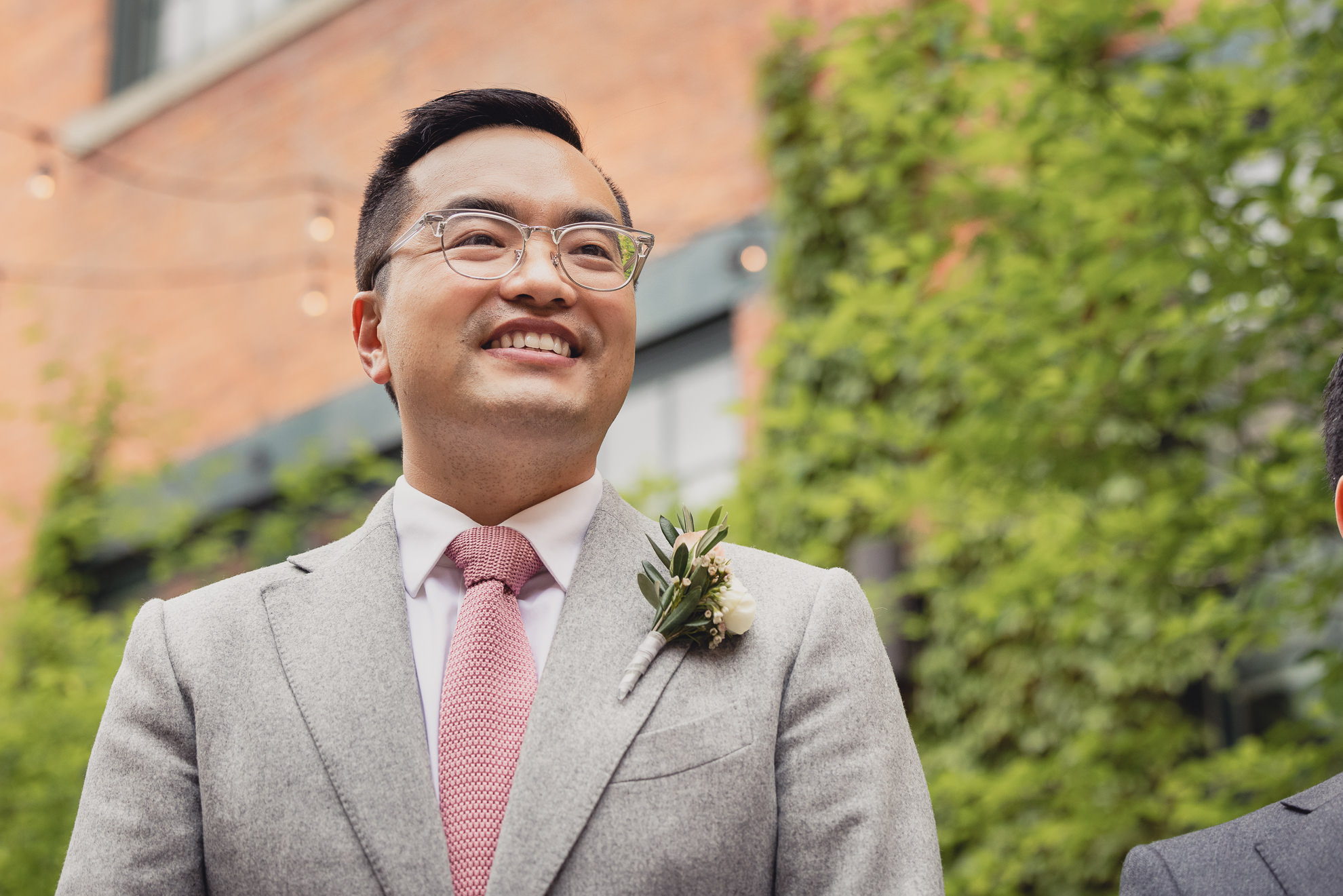 groom smiles at bride during wedding ceremony at the Foundry Suites in Buffalo, NY