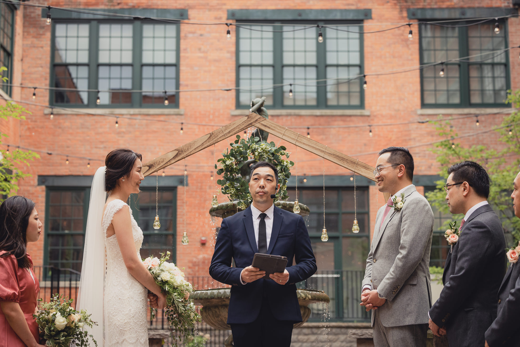 bride and groom smile at each other during wedding ceremony at the Foundry Suites in Buffalo, NY
