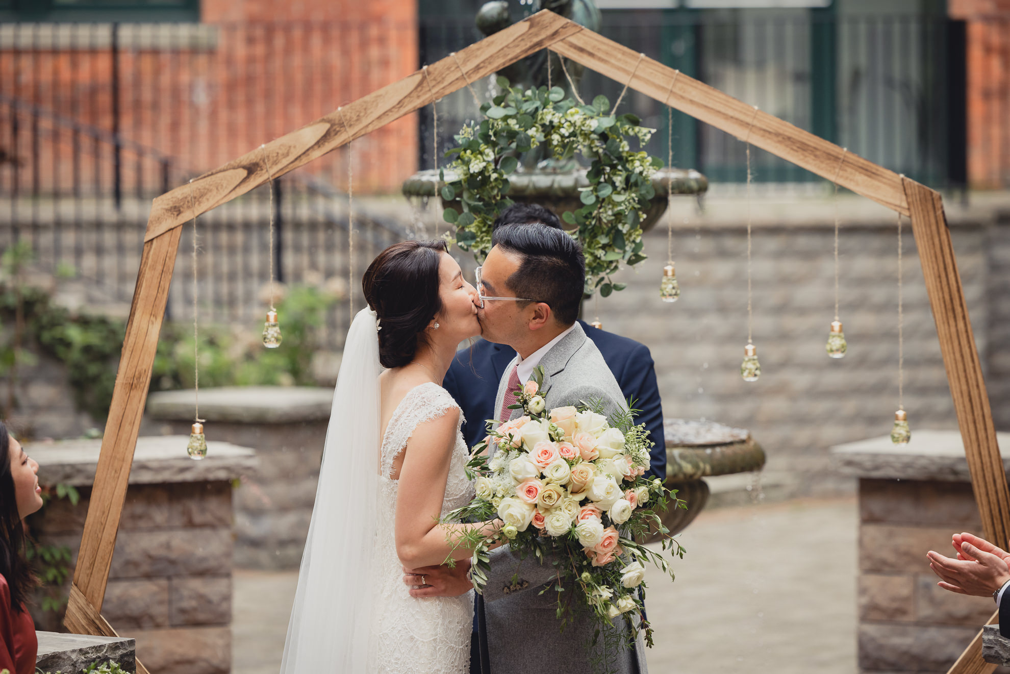 bride and groom kiss during wedding ceremony at the Foundry Suites in Buffalo, NY