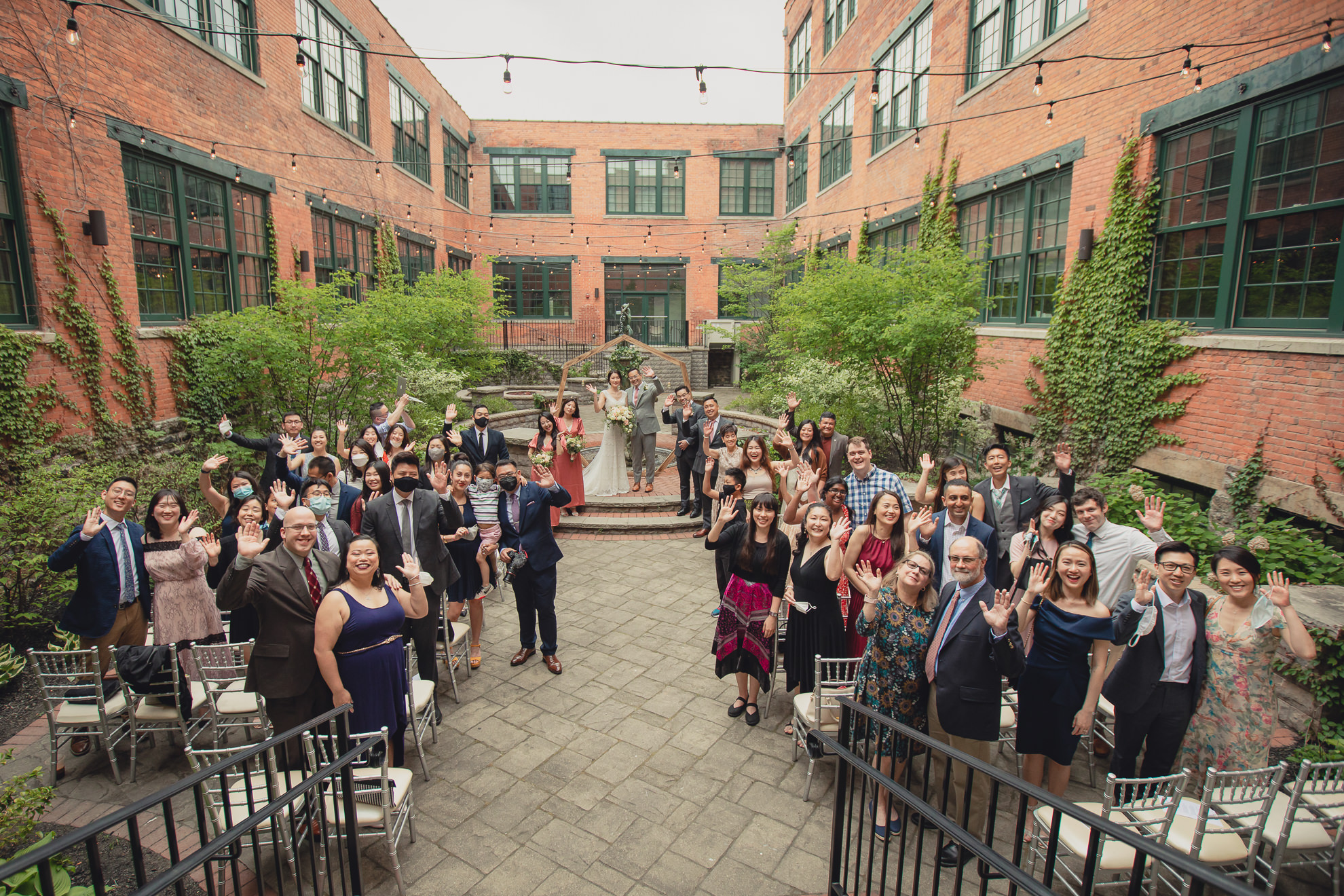 guests wave to photographer during wedding ceremony at the Foundry Suites in Buffalo, NY