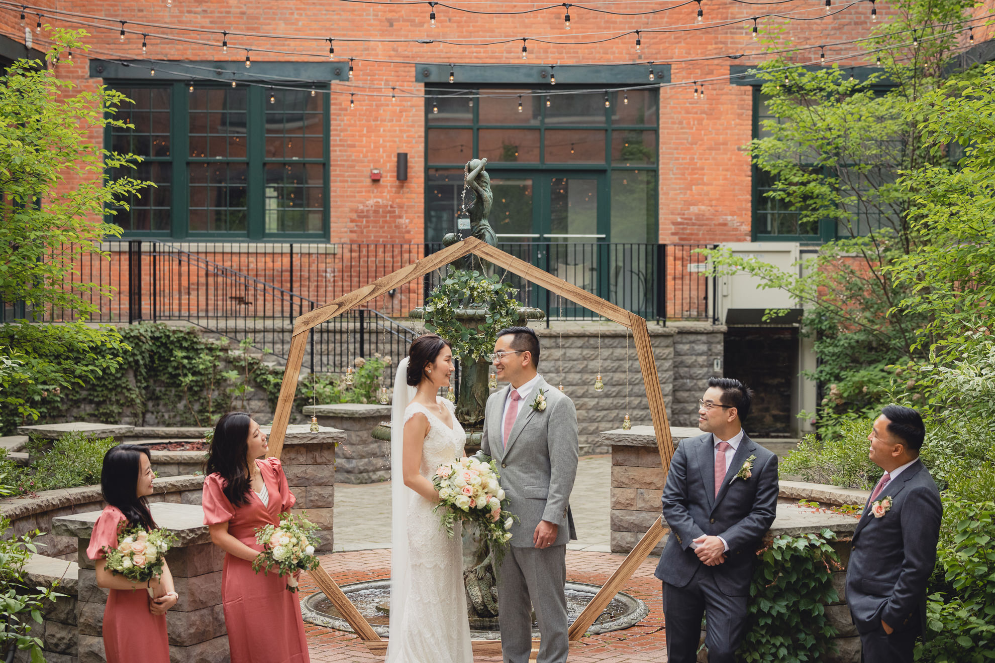 bride and groom pose for photographer during wedding at the Foundry Suites in Buffalo, NY
