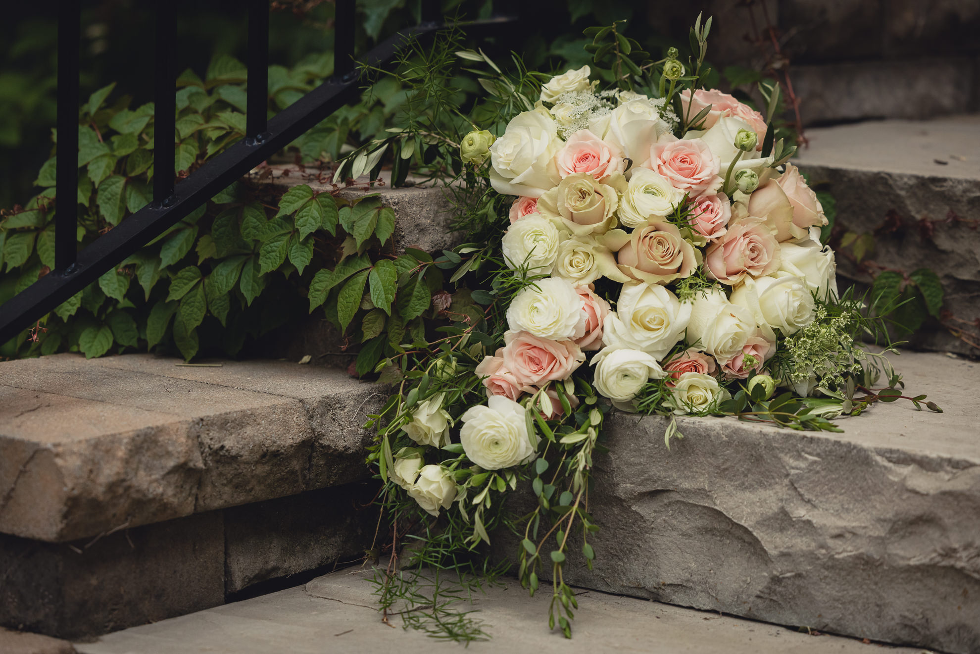 flowers from north park florist sit on steps at the Foundry Suites during wedding in Buffalo, NY