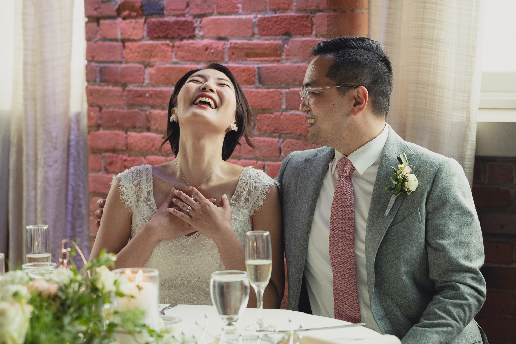 bride and groom laugh during speeches during wedding reception at the Foundry Suites in Buffalo, NY