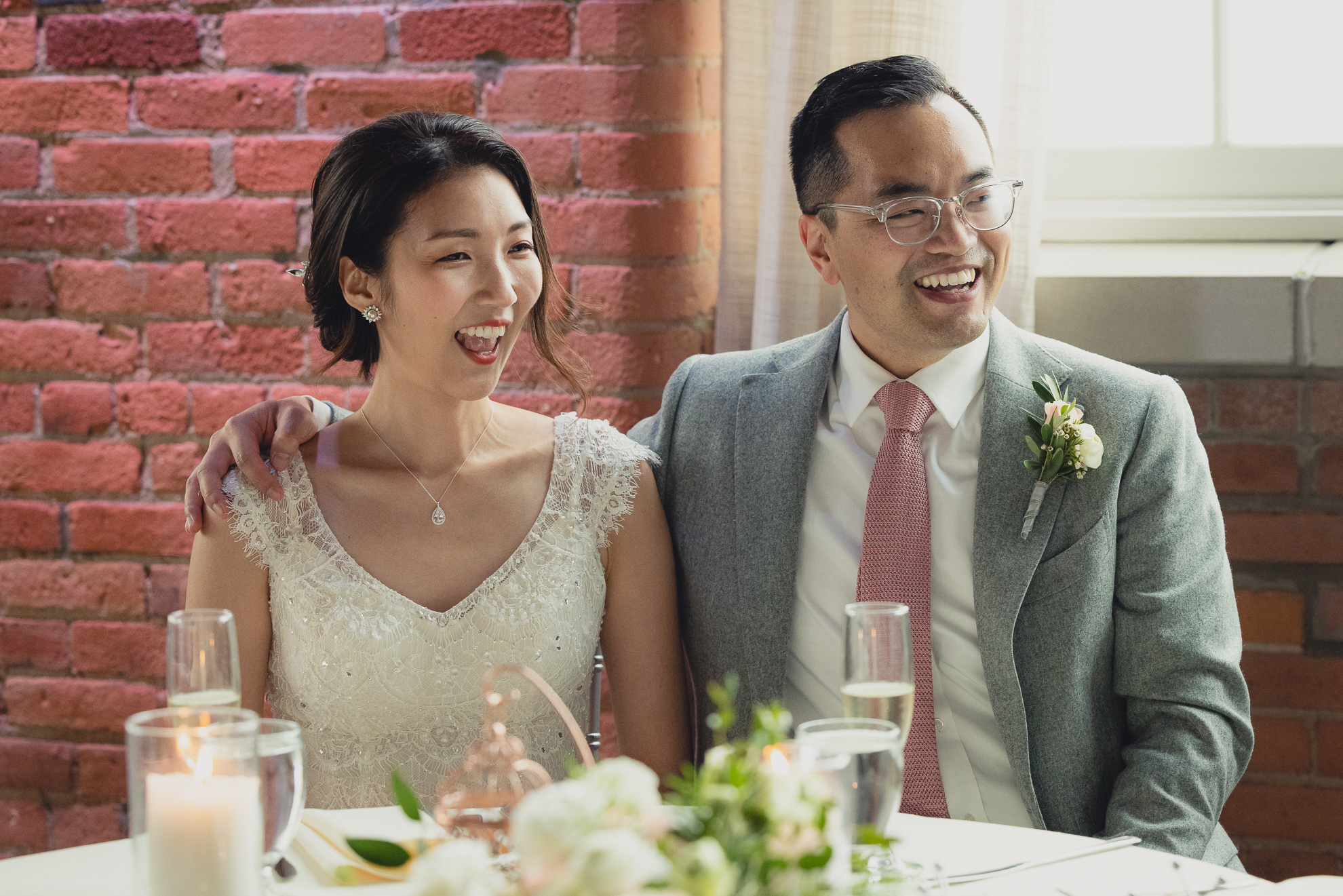 bride and groom laugh during speeches during wedding reception at the Foundry Suites in Buffalo, NY
