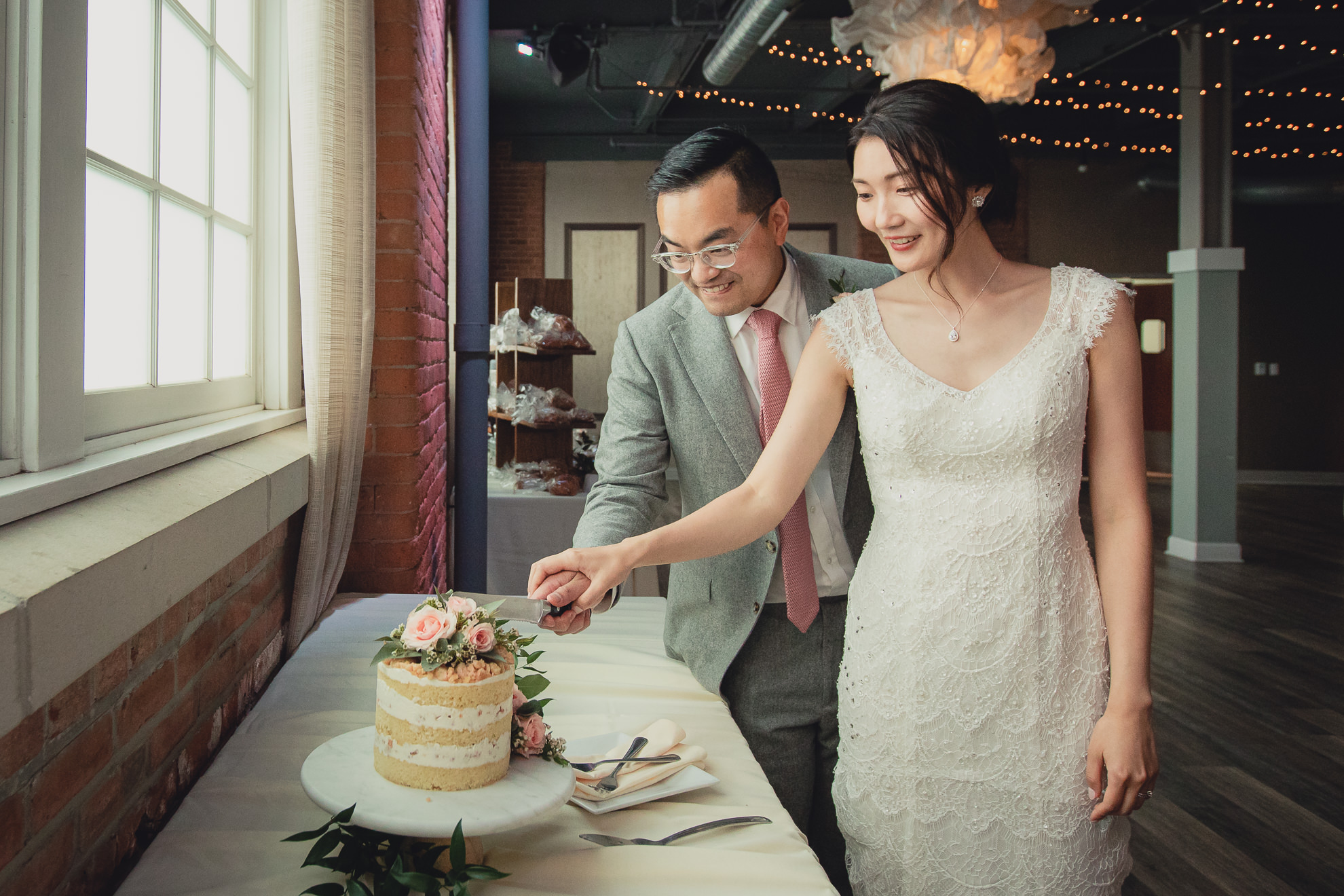 bride and groom cut cake during wedding reception at the Foundry Suites in Buffalo, NY