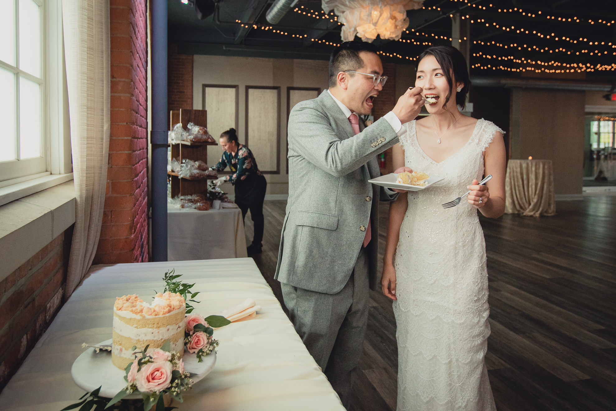 bride and groom eat cake during wedding reception at the Foundry Suites in Buffalo, NY