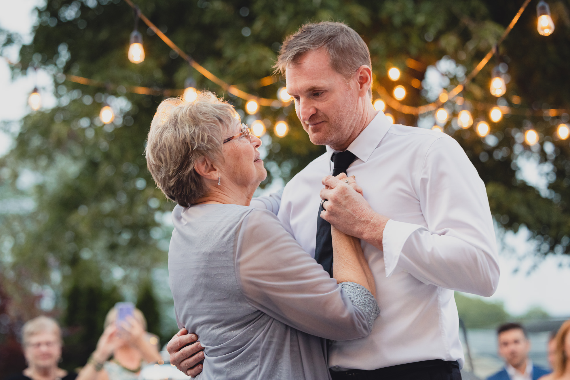groom and mother dance during their backyard tented wedding in Buffalo, NY
