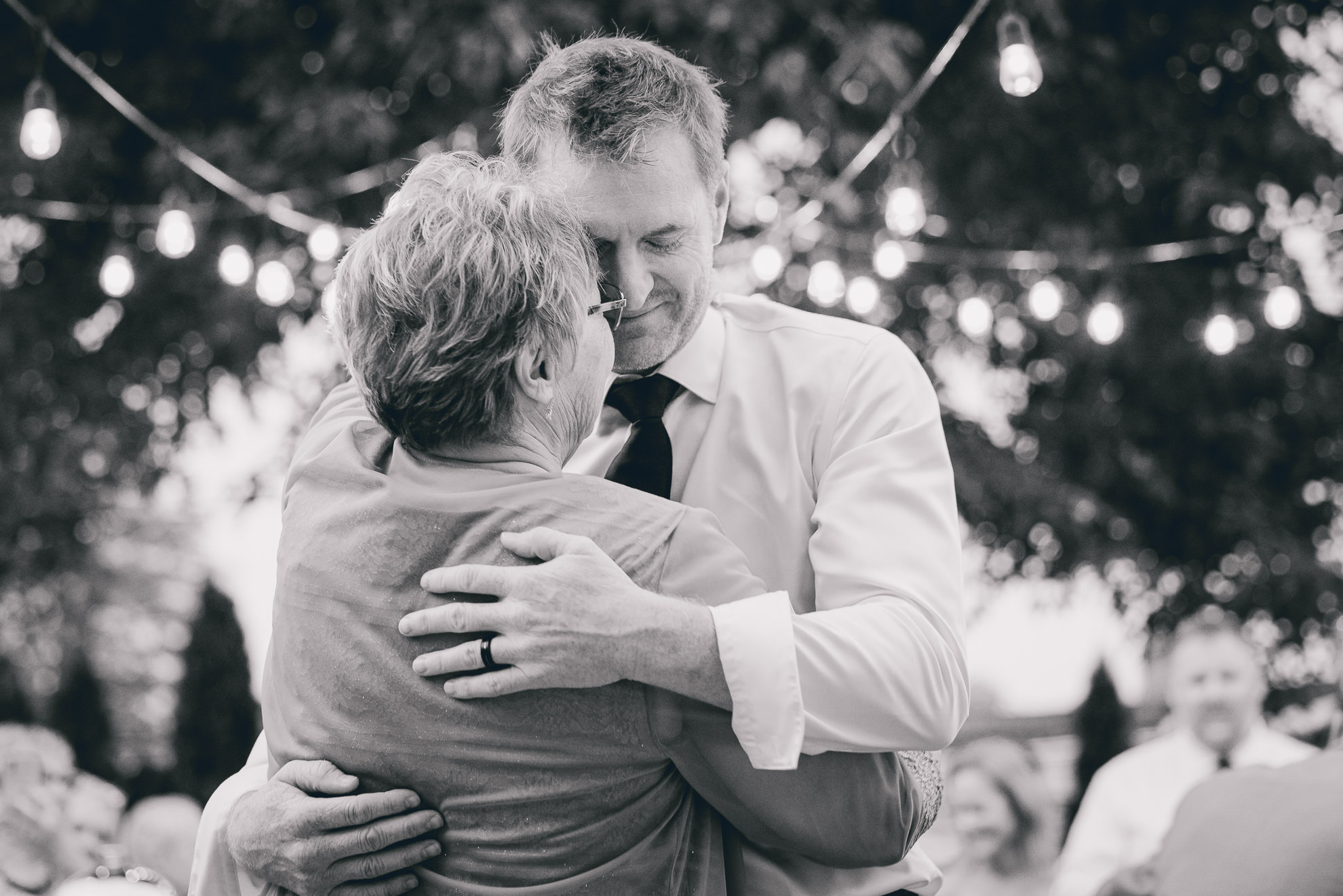 groom and mother dance during their backyard tented wedding in Buffalo, NY