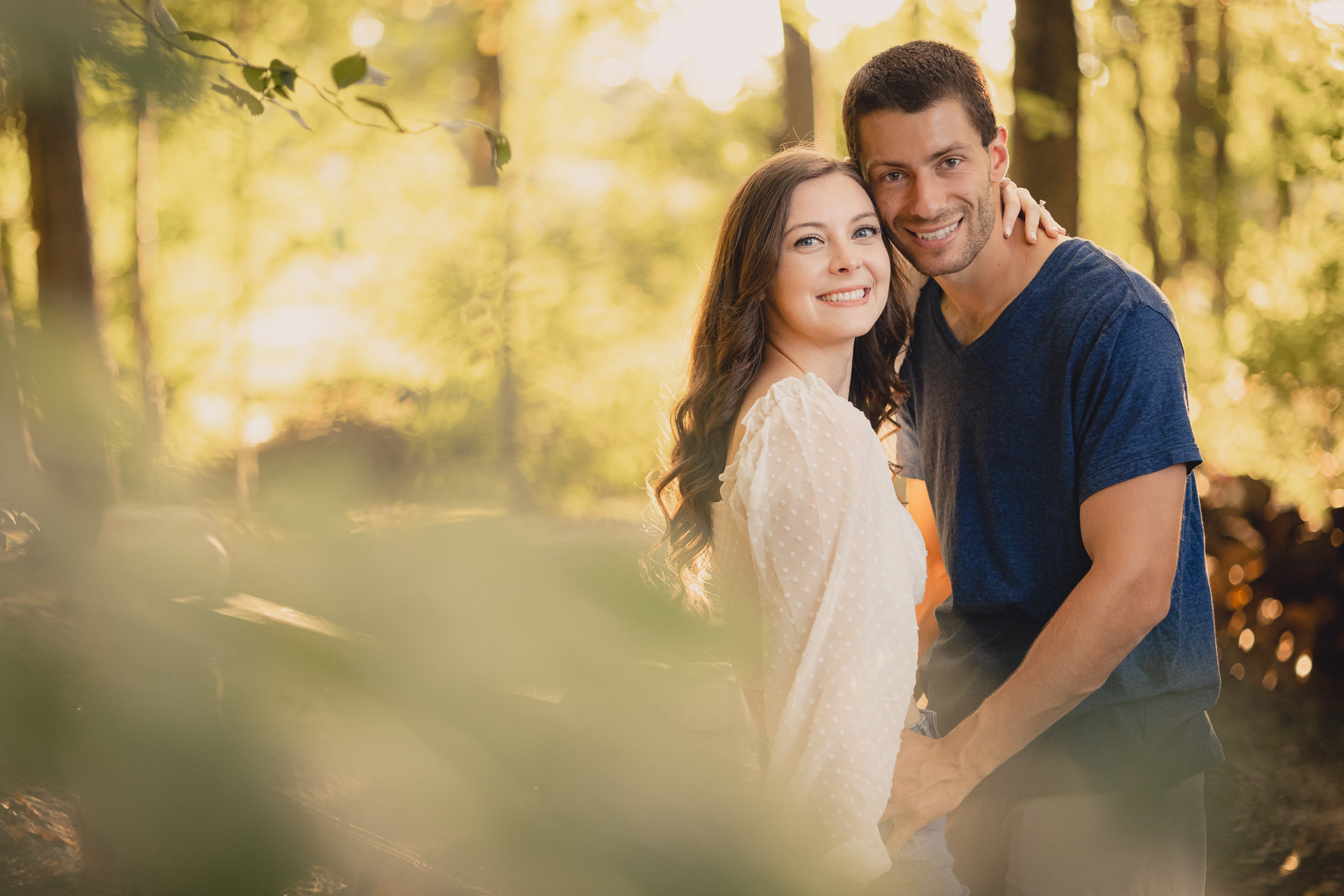 engaged couple poses in woods during engagement photography session at best location near Buffalo, NY