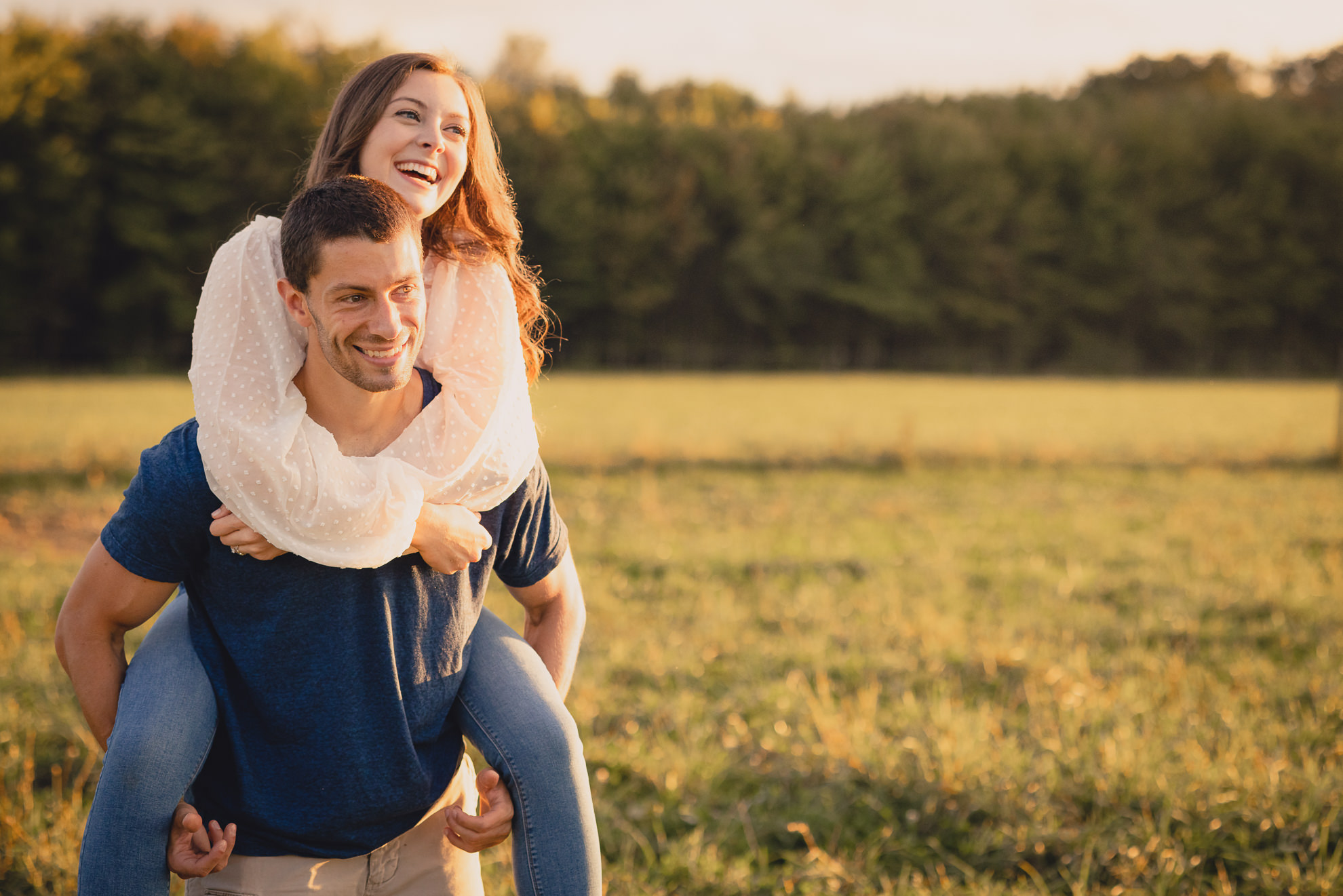 engaged couple poses in field during engagement photography session at best location near Buffalo, NY