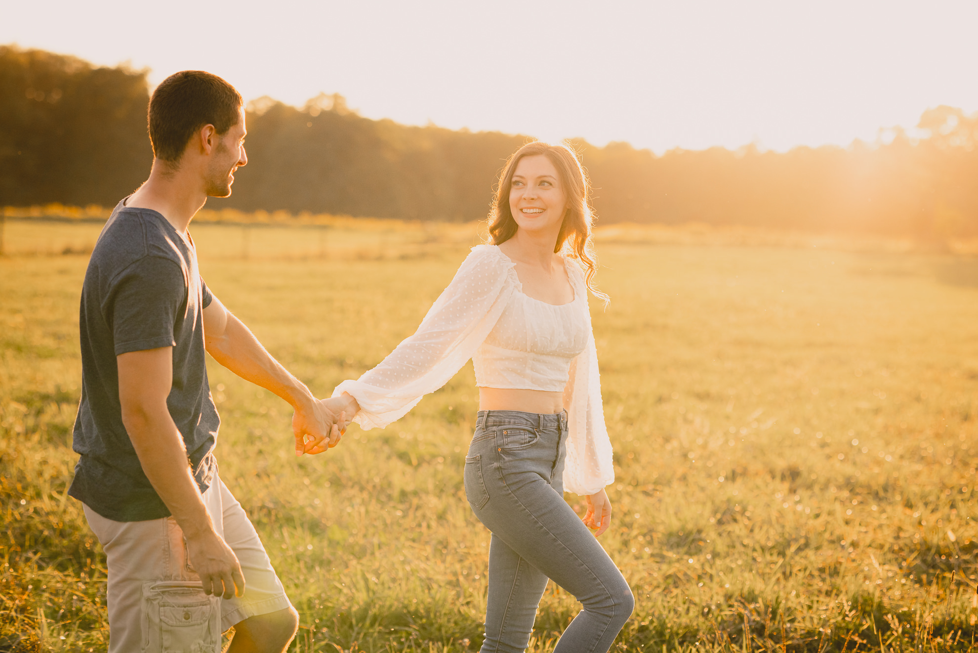 engaged couple poses in field during engagement photography session at best location near Buffalo, NY