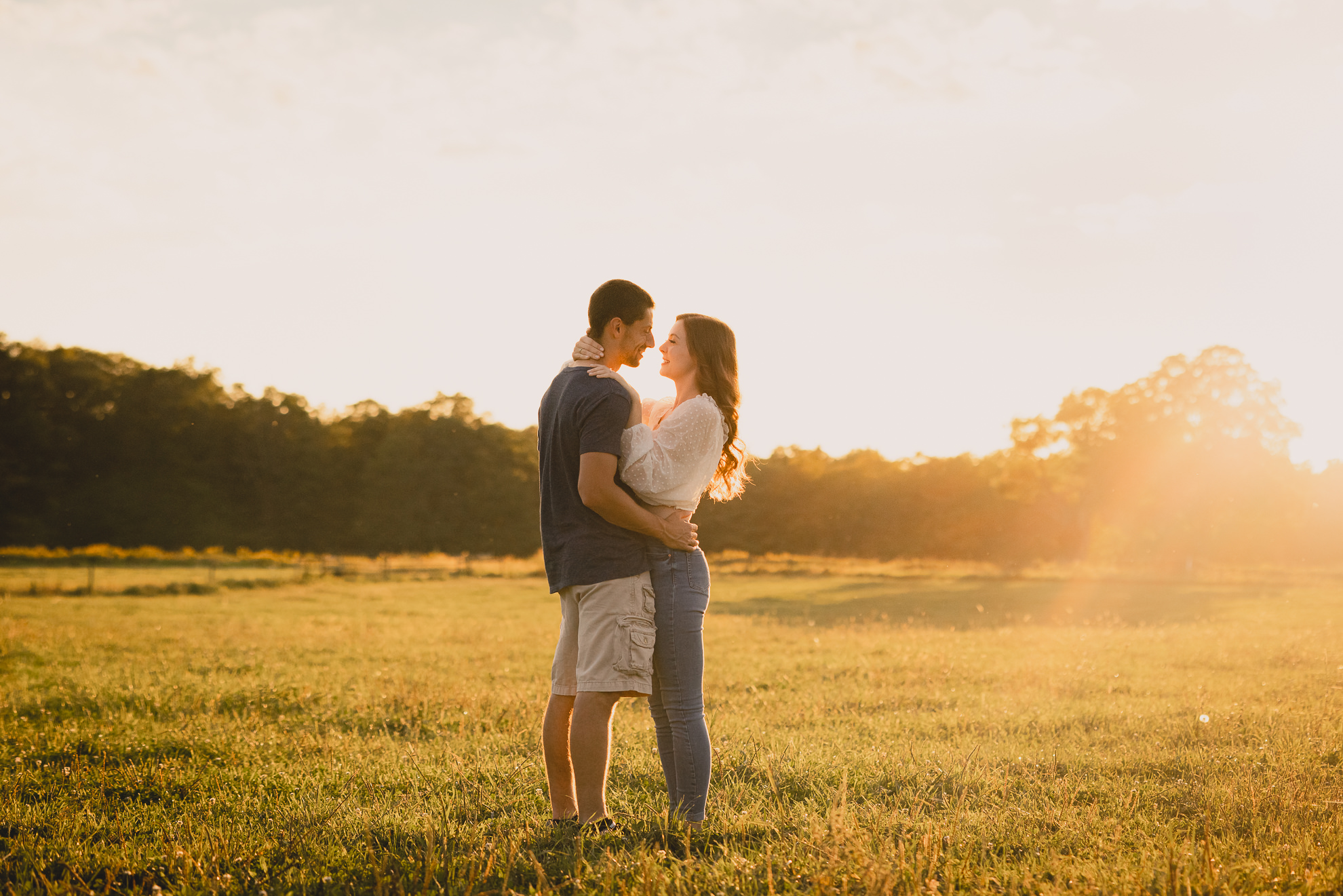 engaged couple poses in field during engagement photography session at best location near Buffalo, NY