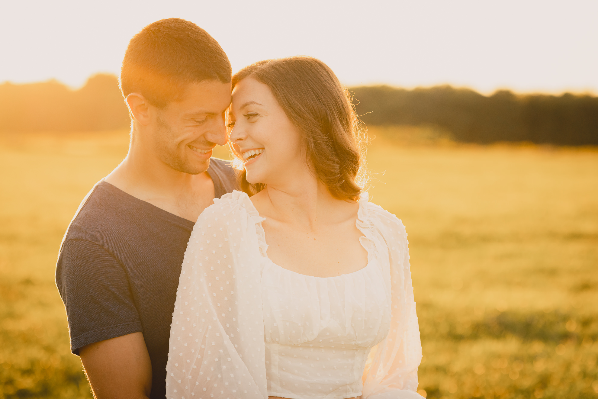 engaged couple poses in field during engagement photography session at best location near Buffalo, NY