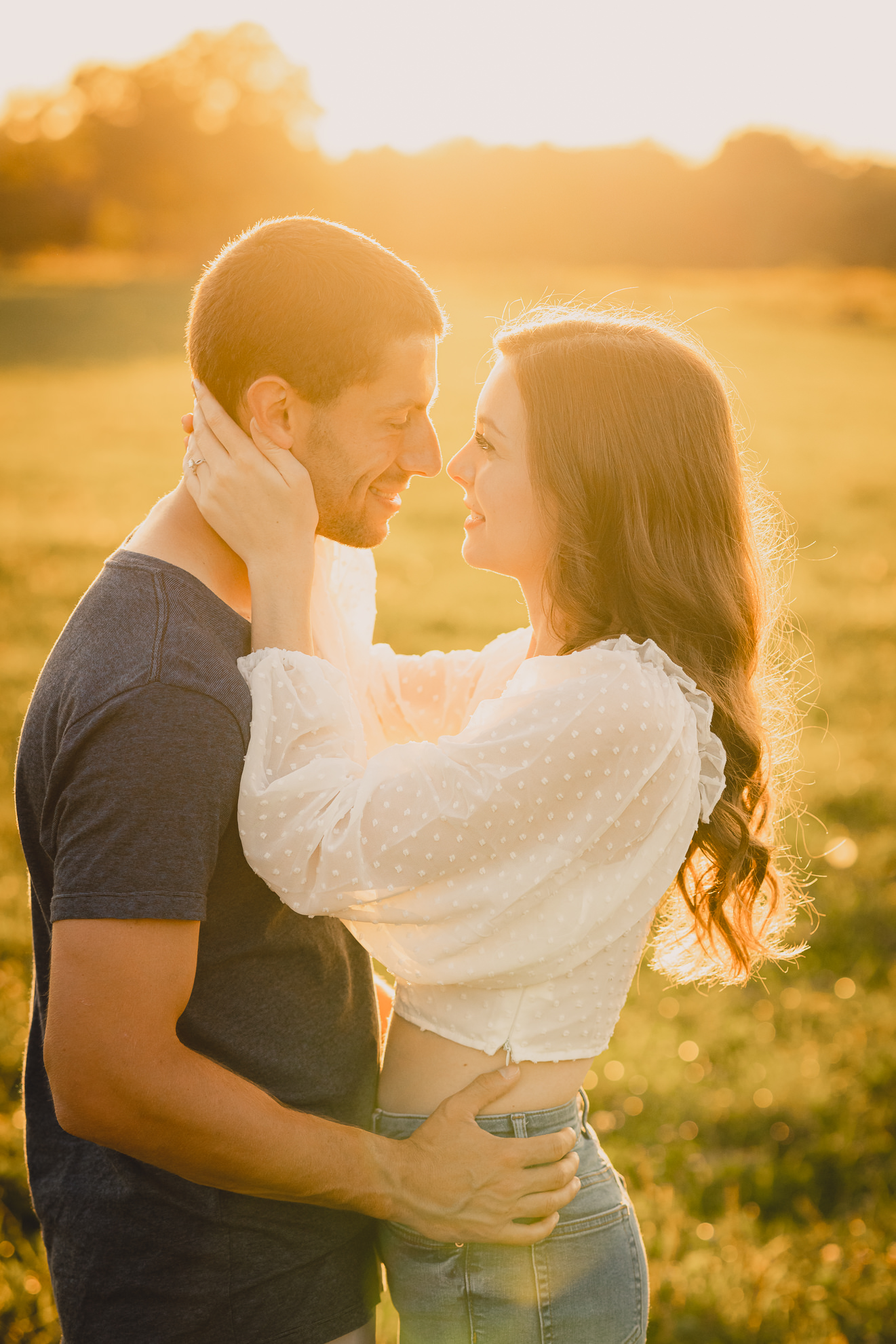 engaged couple poses in field during engagement photography session at best location near Buffalo, NY
