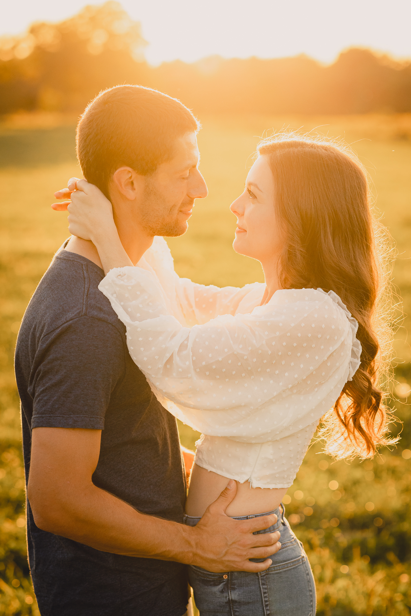engaged couple poses in field during engagement photography session at best location near Buffalo, NY