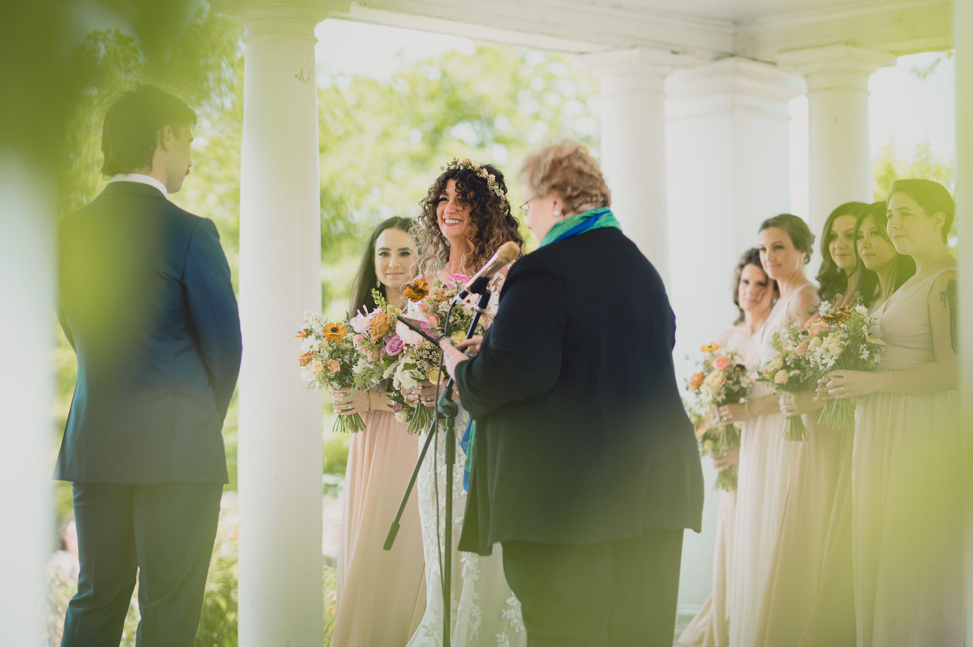 bride smiles at groom at the terrace at marcy casino rose garden wedding ceremony