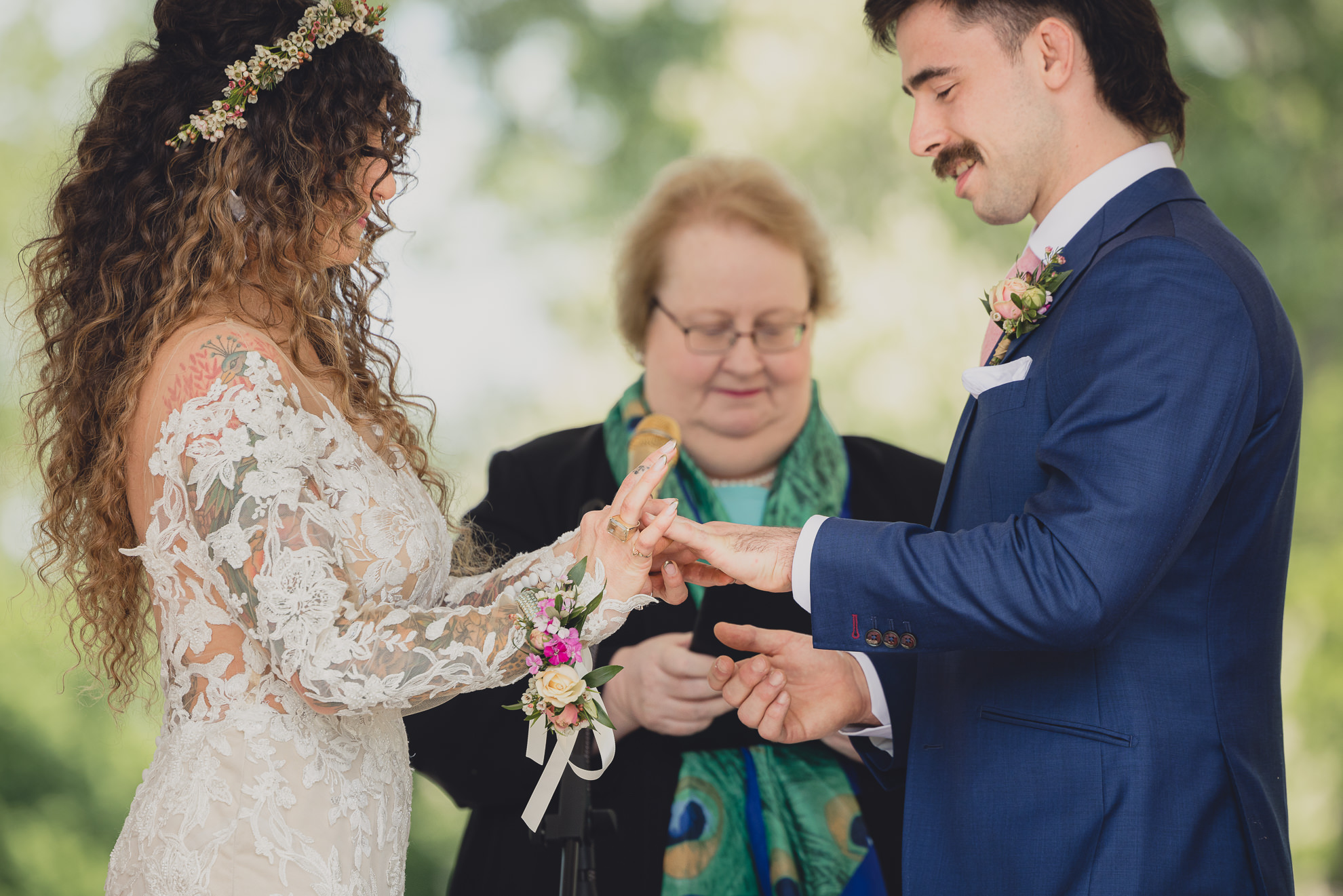 couple exchanges rings at the terrace at marcy casino rose garden wedding ceremony