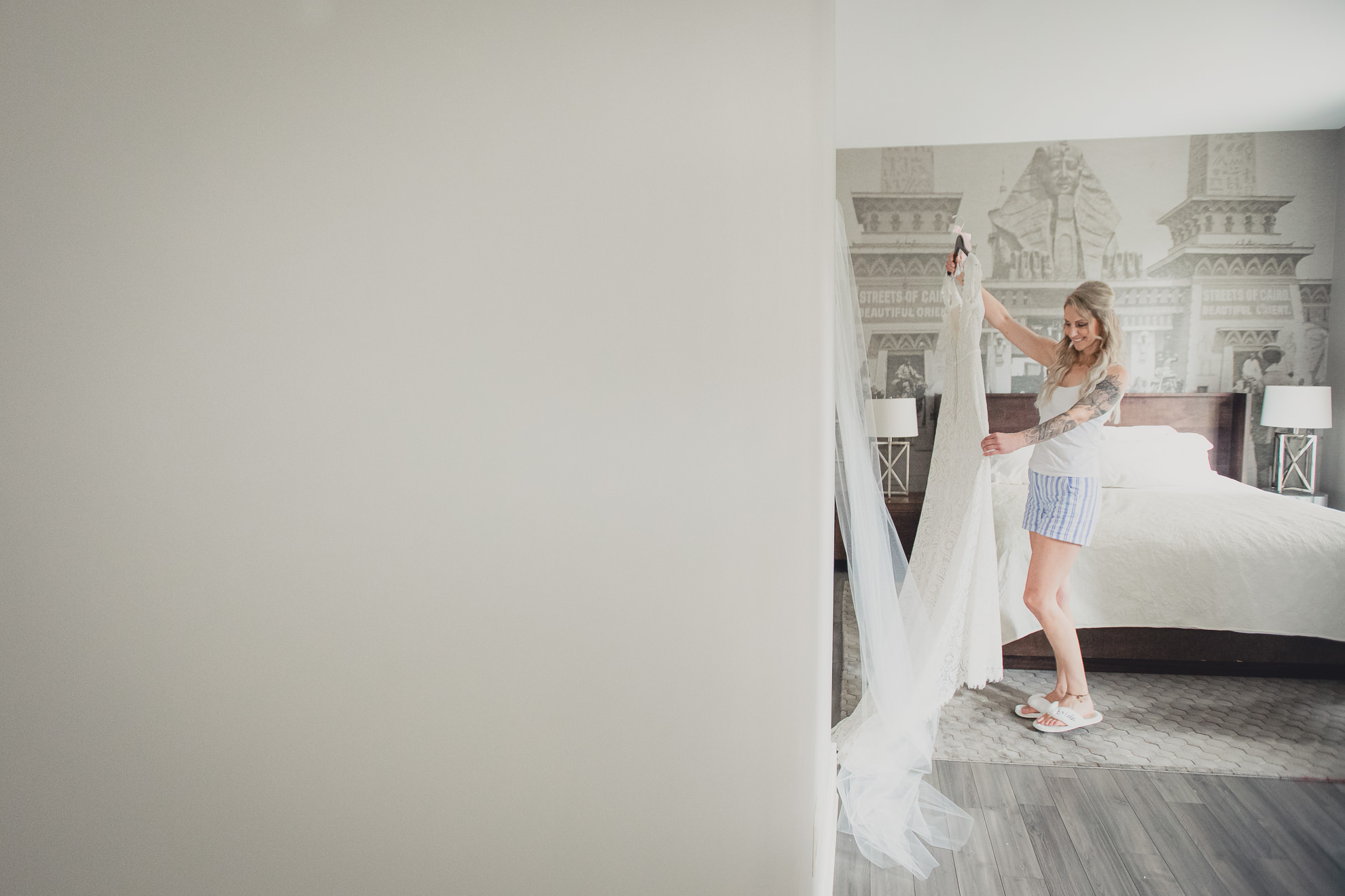 bride looks at dress on hangar while getting ready for wedding at Hotel Lafayette in Buffalo, NY