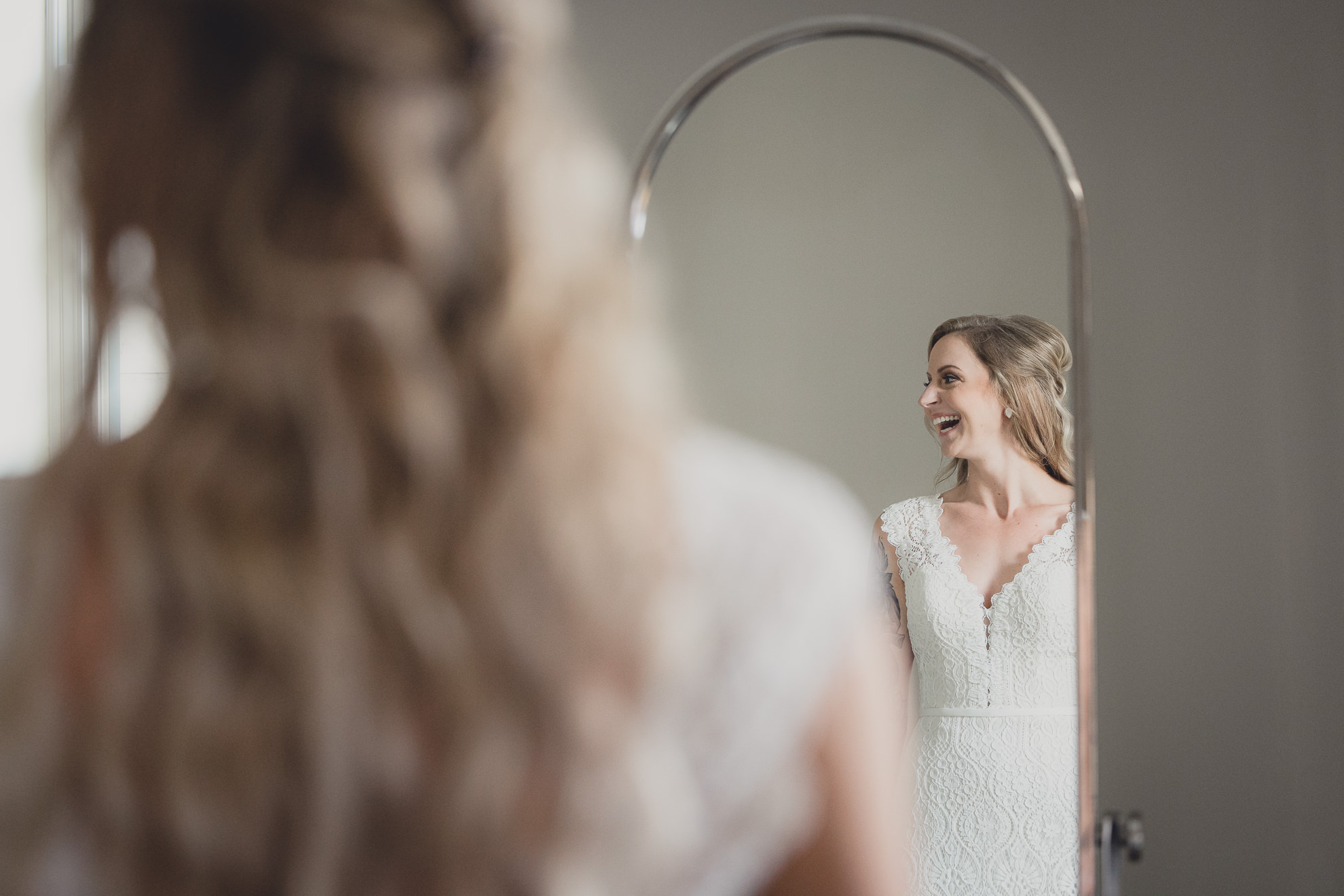 bride smiles in mirror while getting ready for wedding at Hotel Lafayette in Buffalo, NY