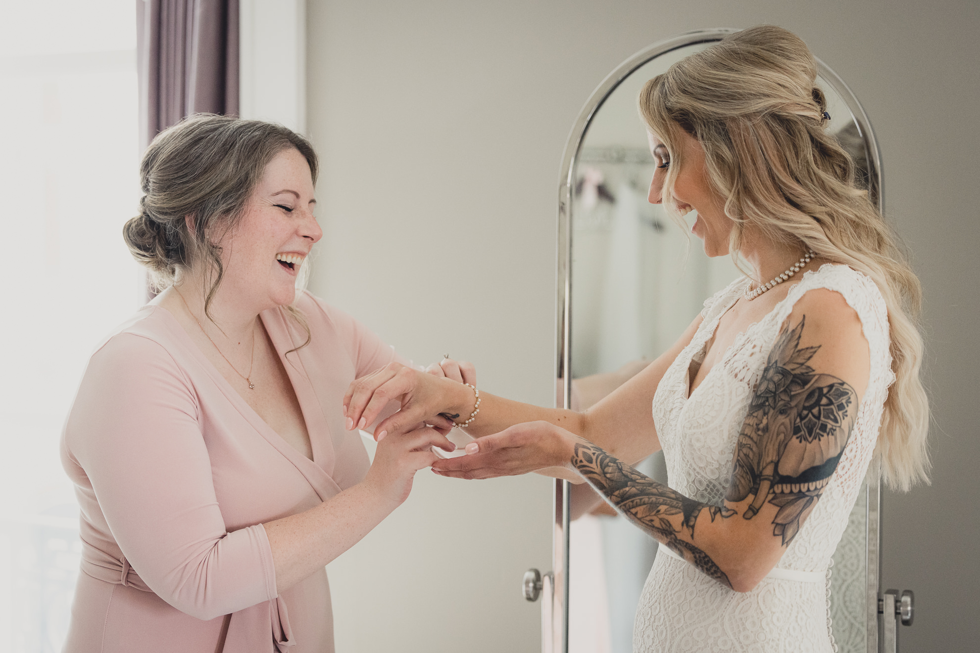 bridesmaid assists bride while getting ready for wedding at Hotel Lafayette in Buffalo, NY