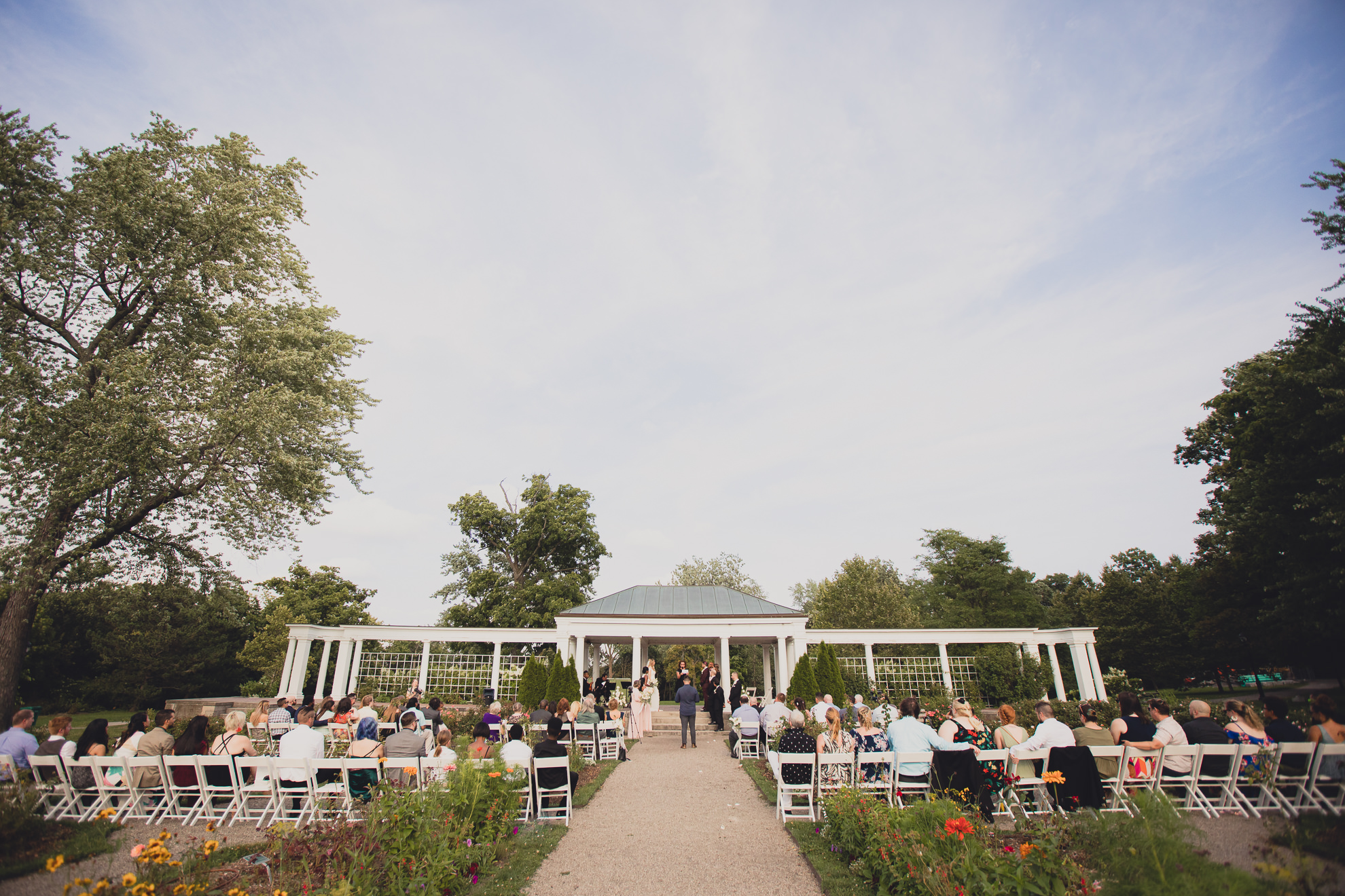guests look on during wedding ceremony in rose garden at Marcy Casino in Buffalo, NY