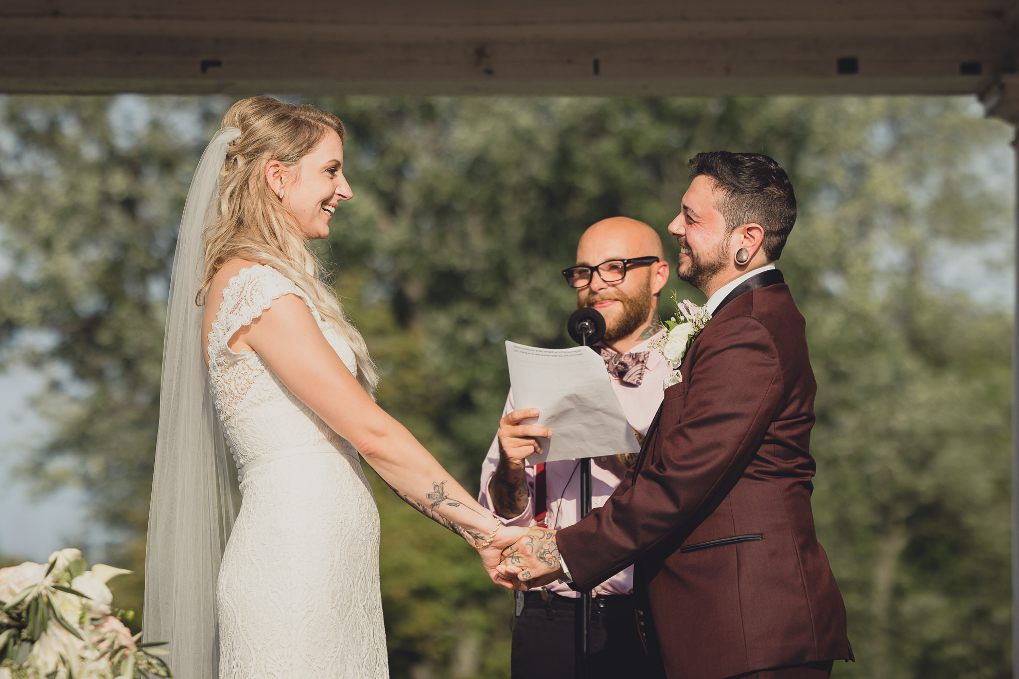 bride and groom exchange vows during wedding ceremony in rose garden at Marcy Casino in Buffalo, NY