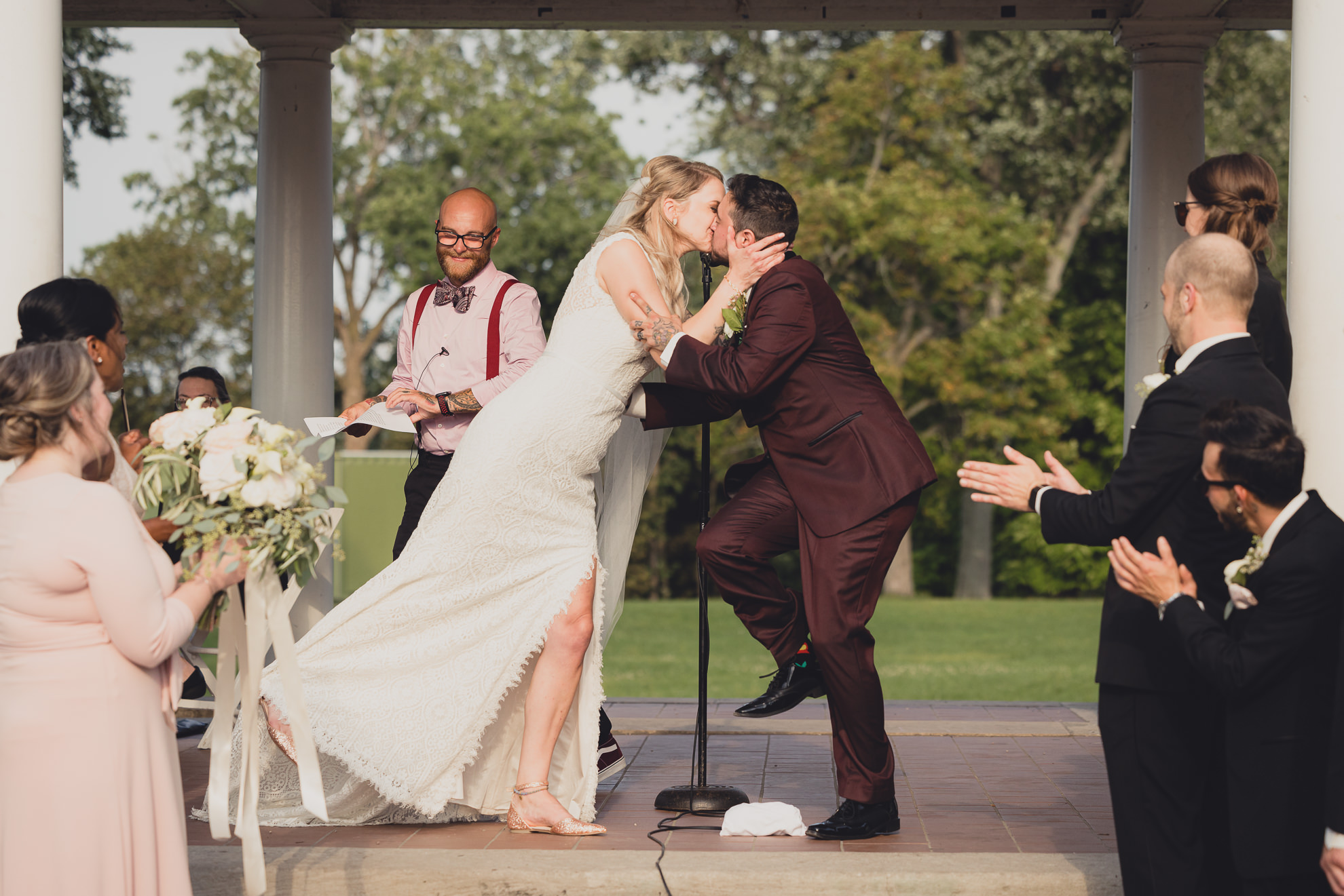 bride and groom kiss during wedding ceremony in rose garden at Marcy Casino in Buffalo, NY