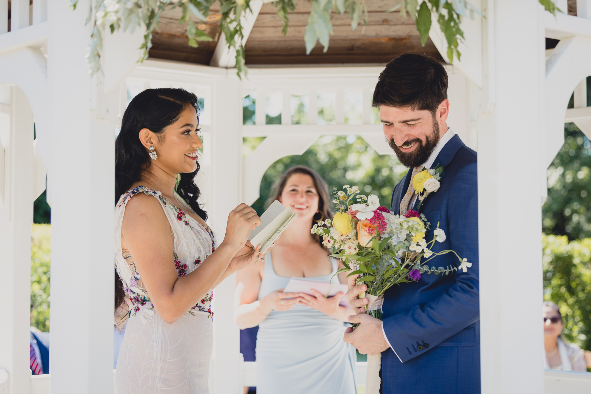 bride and groom exchange vows during wedding ceremony in gazebo at mansion at Knox Farm in East Aurora, NY