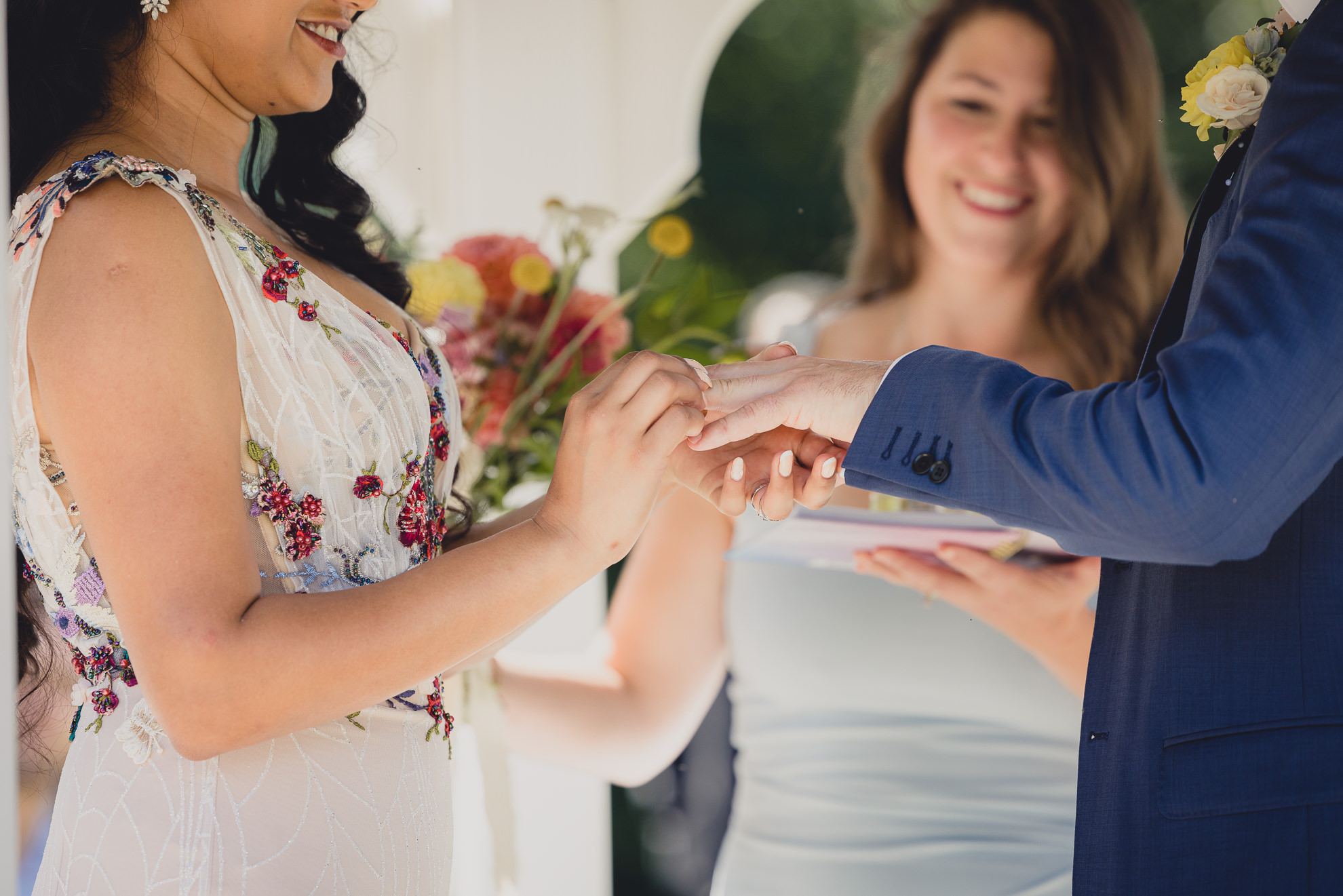 couple exchanges rings during wedding ceremony in gazebo at mansion at Knox Farm in East Aurora, NY
