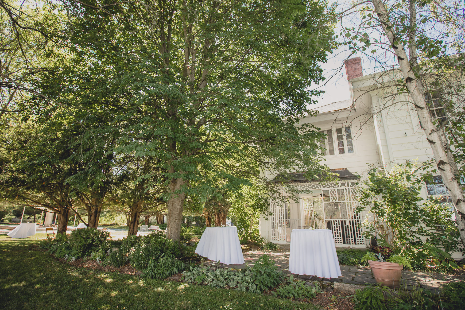cocktail tables outside mansion at outdoor tented wedding reception at Knox Farm in East Aurora, NY