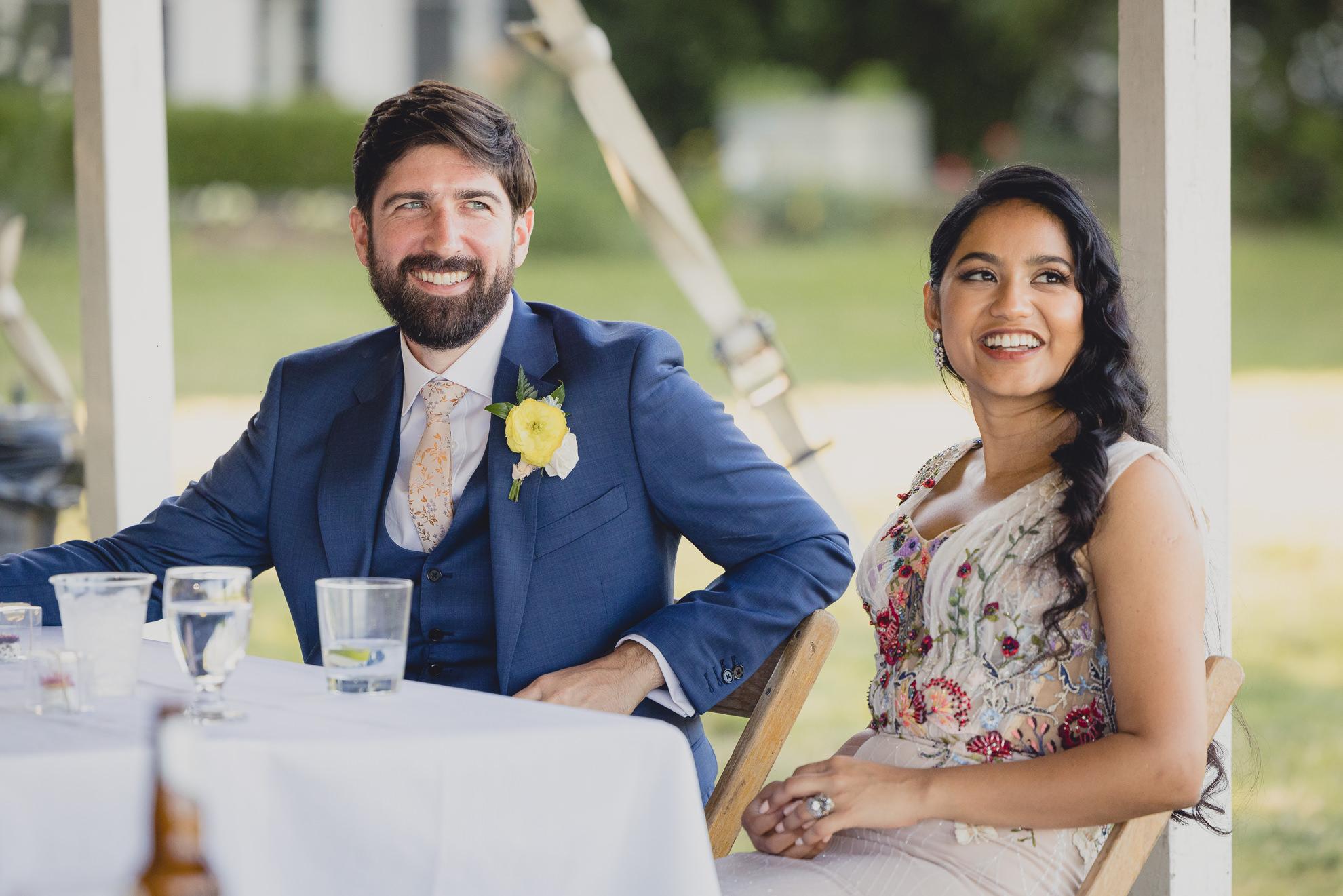 bride and groom react to speech at outdoor tented wedding reception at Knox Farm in East Aurora, NY