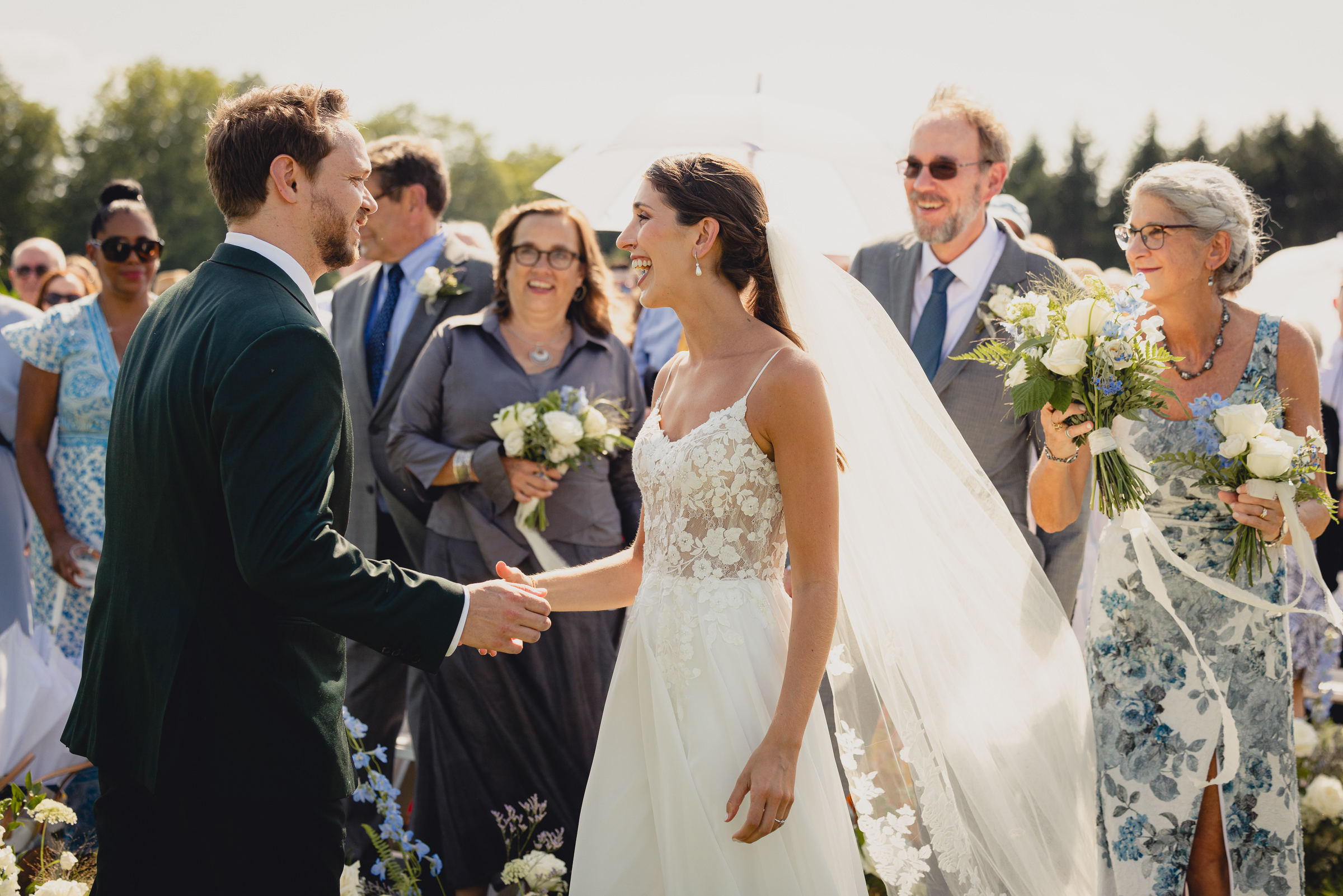bride walks down aisle with parents at wedding ceremony at The North Farm overlooking Seneca Lake in Geneva, NY