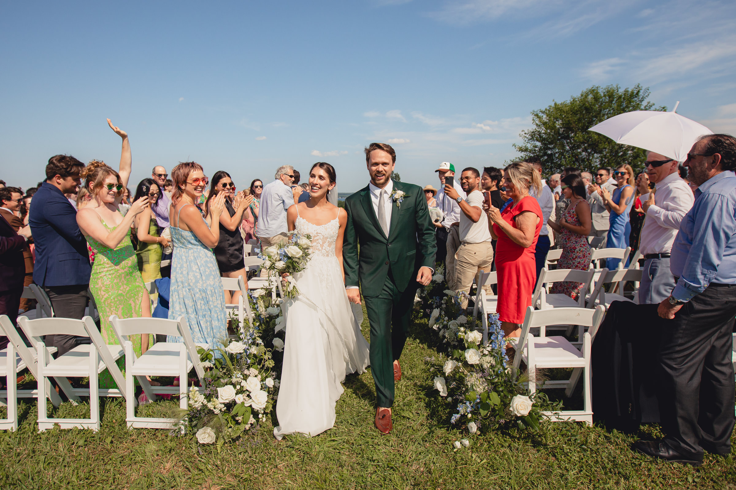 bride and groom walk down aisle wedding ceremony at The North Farm overlooking Seneca Lake in Geneva, NY