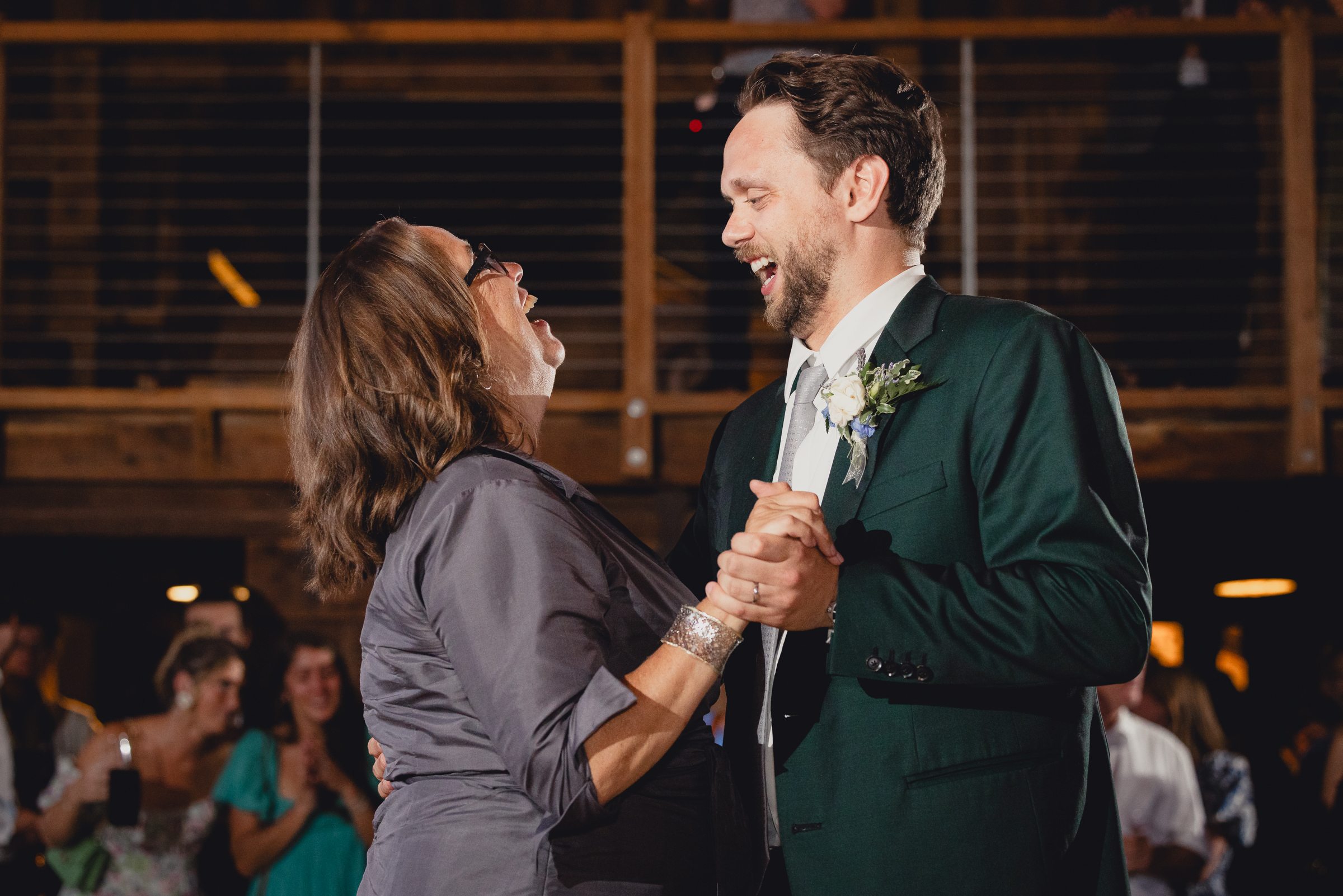 mother and groom dance at wedding reception in barn at The North Farm in Geneva, NY