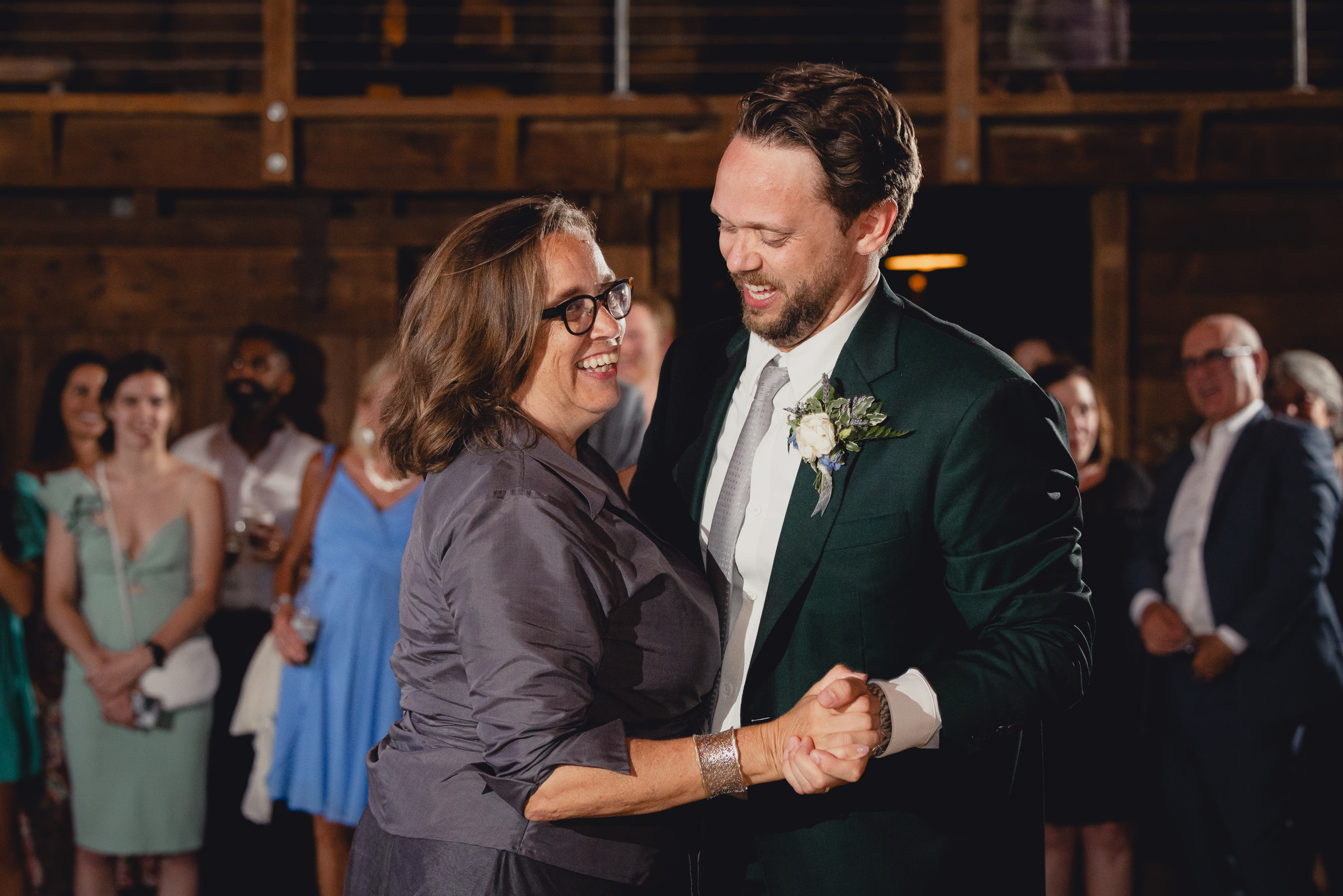 mother and groom dance at wedding reception in barn at The North Farm in Geneva, NY