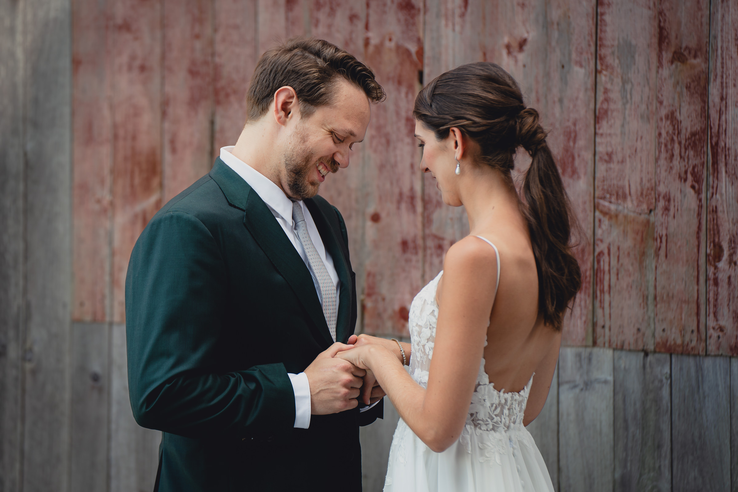 Bride and groom pose for portraits in front of The North Farm barns at a wedding in Geneva, NY