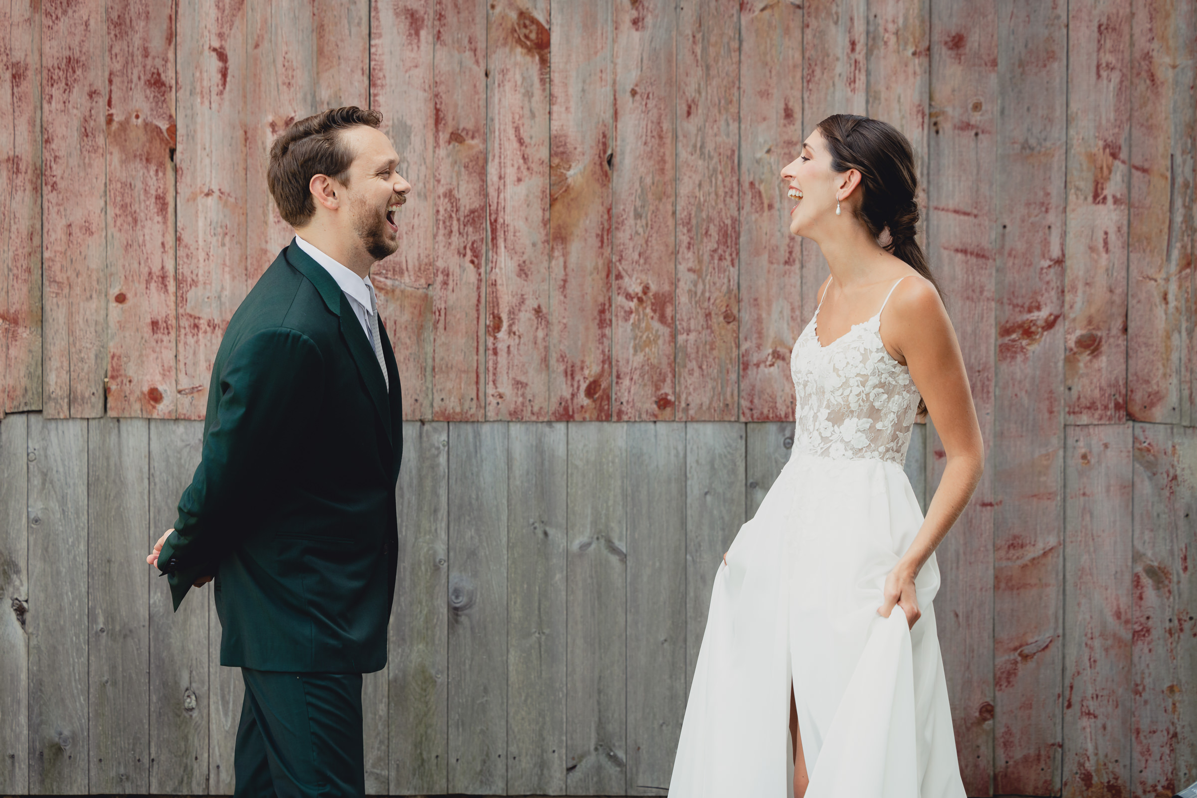 Bride and groom pose for portraits in front of The North Farm barns at a wedding in Geneva, NY