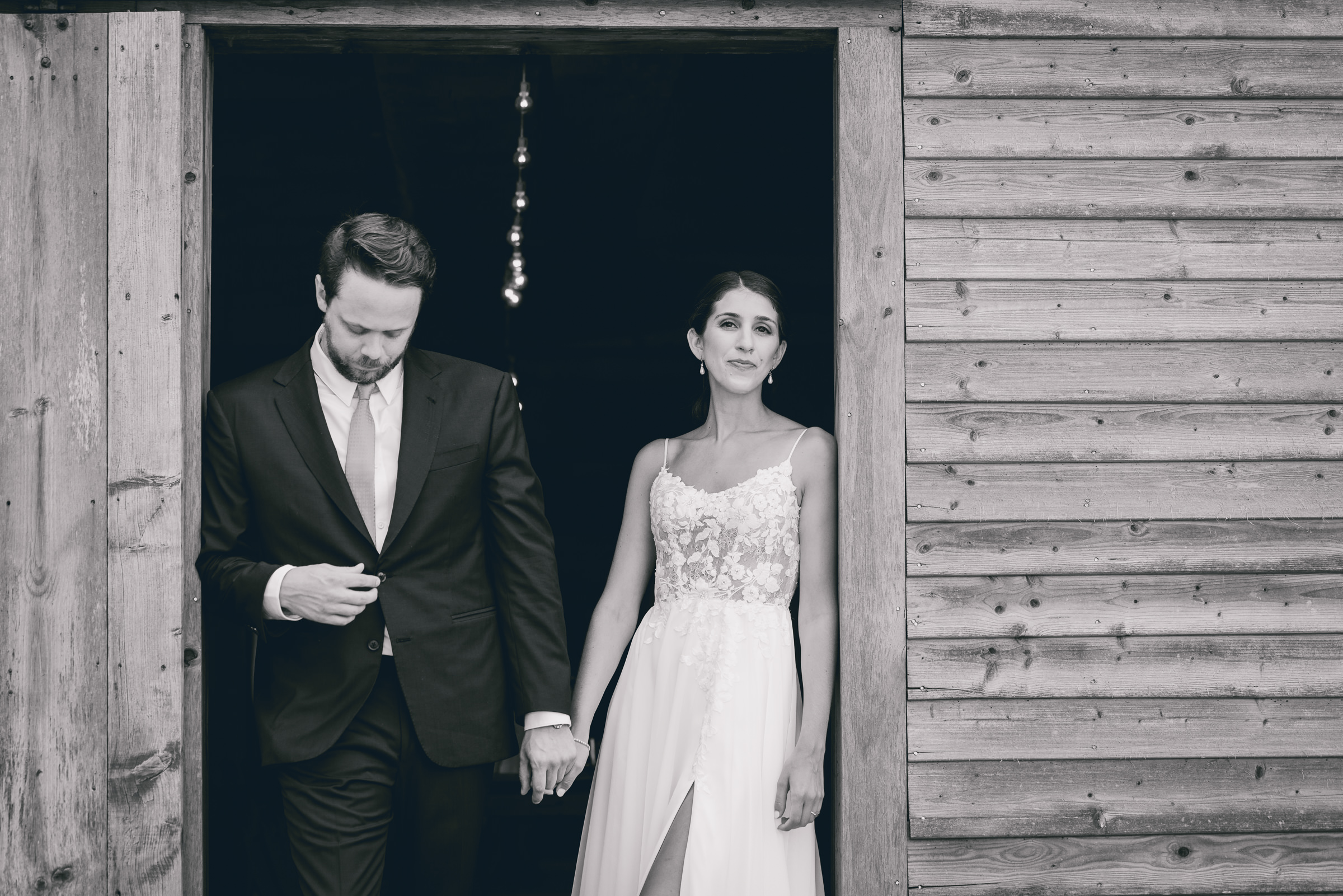 Bride and groom pose for portraits in front of The North Farm barns at a wedding in Geneva, NY