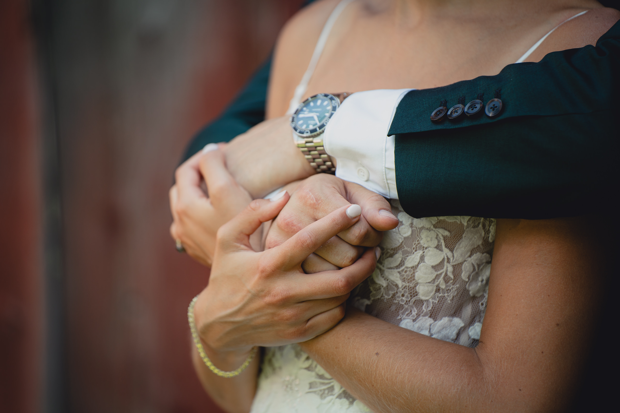 Bride and groom pose for portraits in front of The North Farm barns at a wedding in Geneva, NY