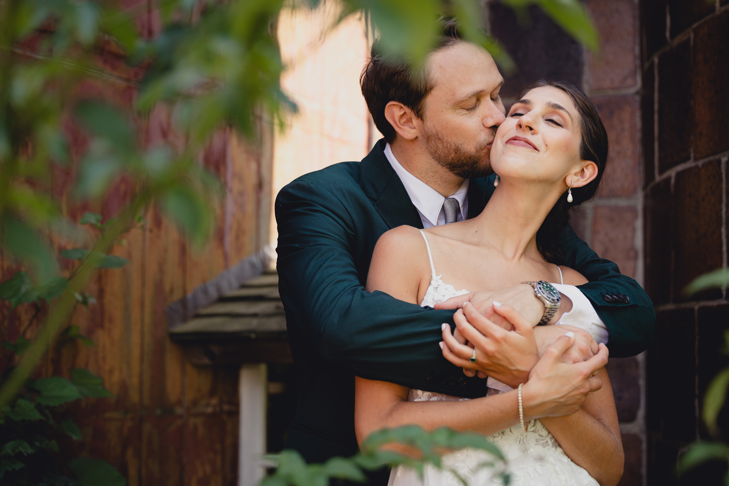 Bride and groom pose for portraits in front of The North Farm barns at a wedding in Geneva, NY