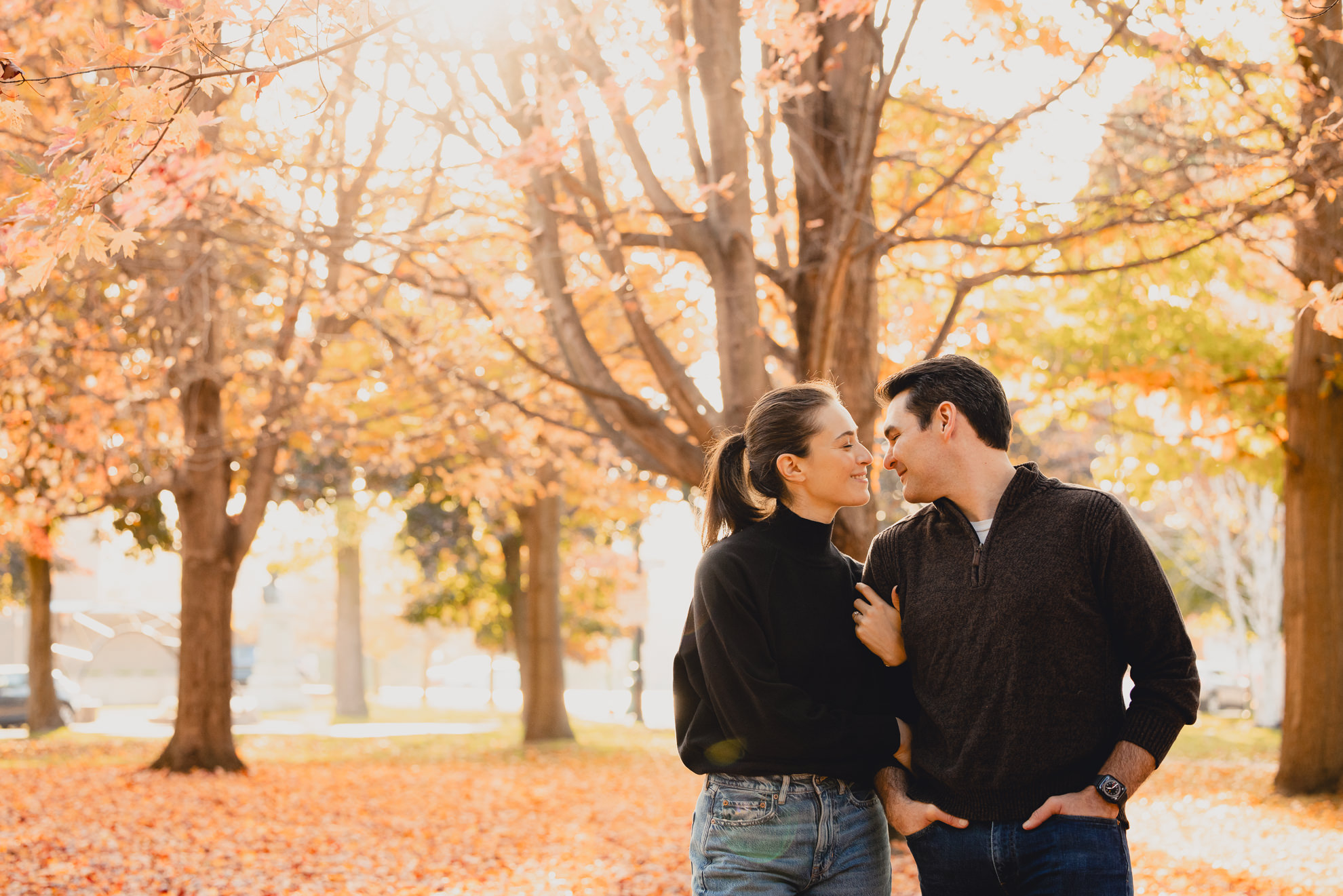 future bride and groom look at each other while linking arms in Allentown section of Buffalo, NY during their wedding engagement photos