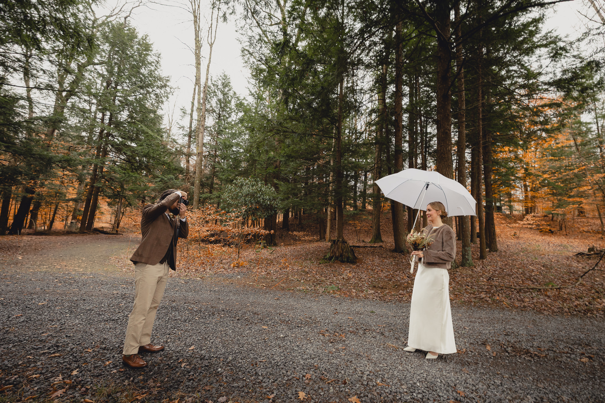 groom photographs bride outside Langston Cottage at Vanderkamp NY before fall wedding elopement in the Adirondacks